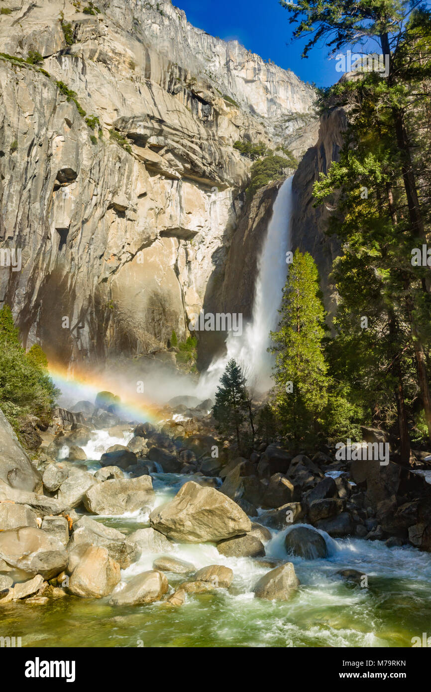 Colore diurno foto verticale di Yosemite Falls nel Parco Nazionale di Yosemite in California, Stati Uniti d'America. Vi è un arcobaleno metà di terra alla base delle cascate. Foto Stock Colore diurno foto verticale di Yosemite Falls nel Parco Nazionale di Yosemite in California, Stati Uniti d'America. Vi è un arcobaleno metà di terra alla base delle cascate. Foto Stock