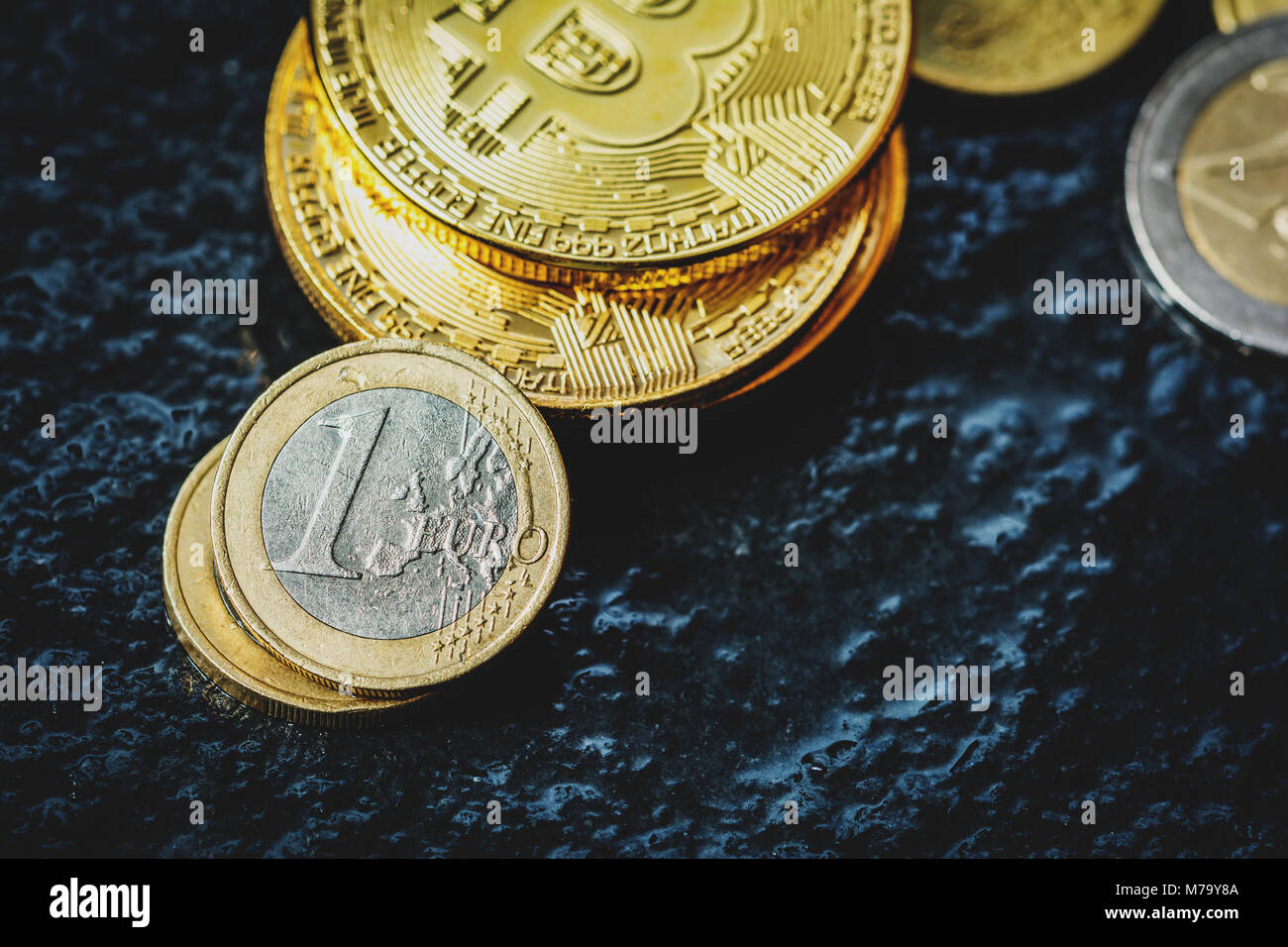 Moneta virtuale Bitcoin e Euro moneta sul tavolo scuro Foto Stock