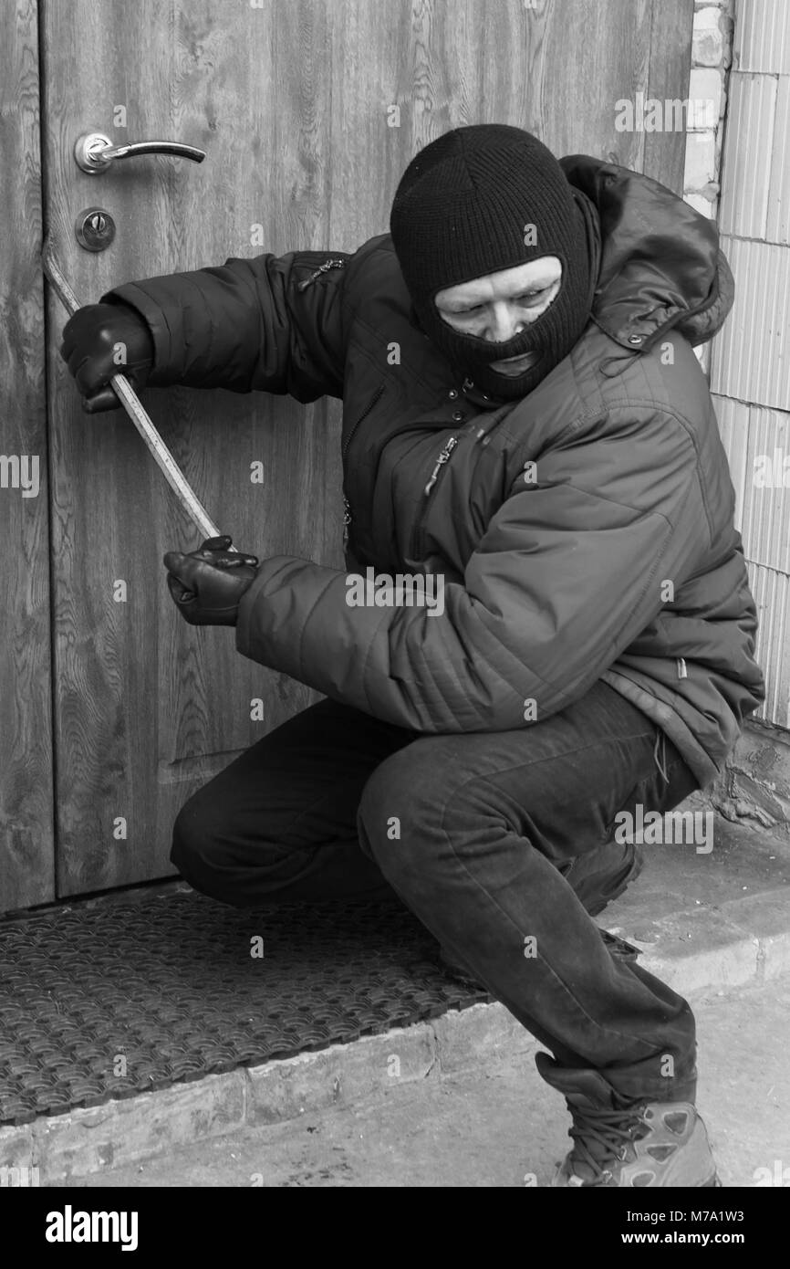 Materia penale si rompe la porta con il piede di porco. ingresso illegale in casa Foto Stock