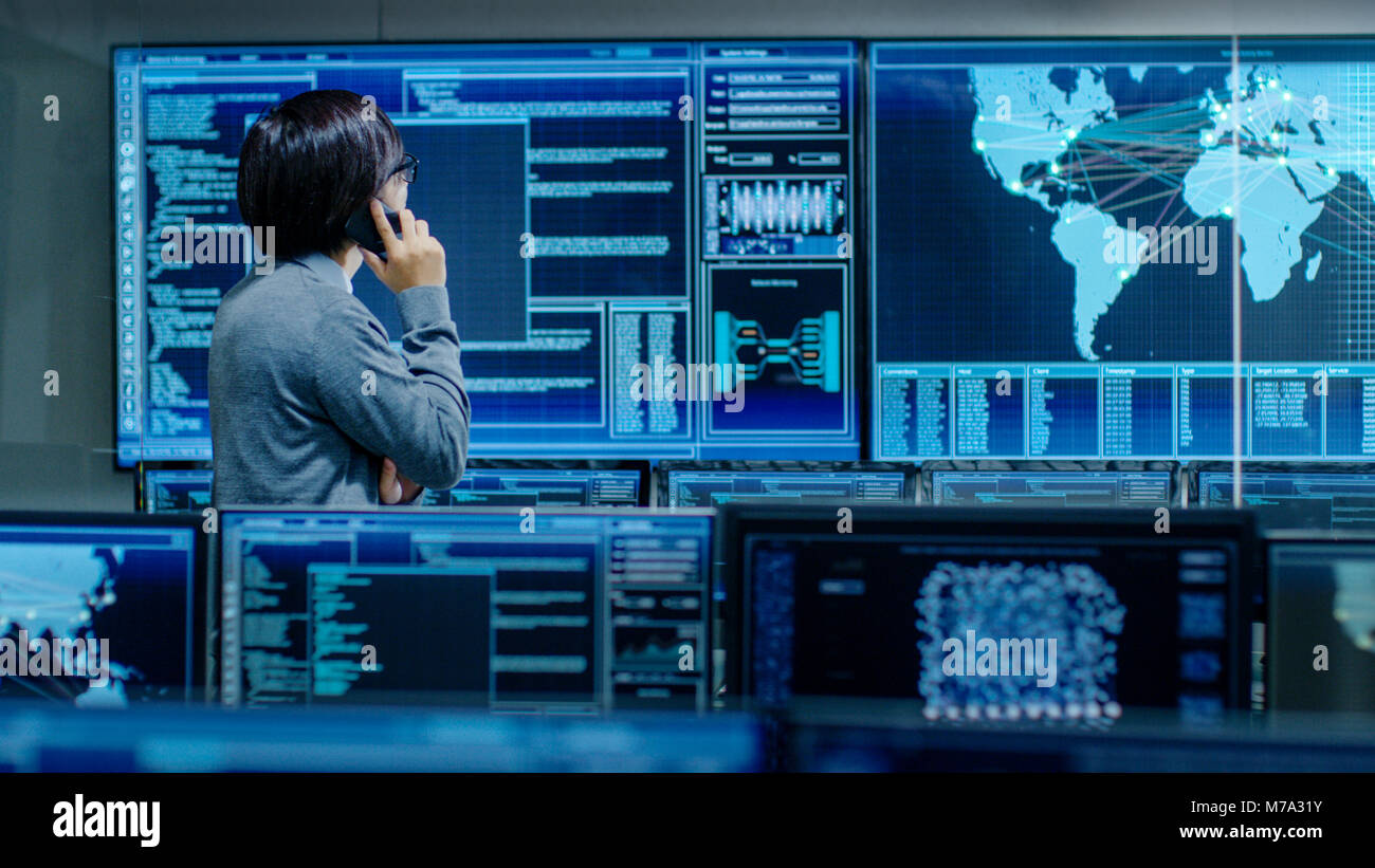 Nel sistema della sala di controllo Amministratore IT parla al telefono. Lui è in un impianto high-tech che lavora per la sorveglianza di reti neurali, dati Foto Stock