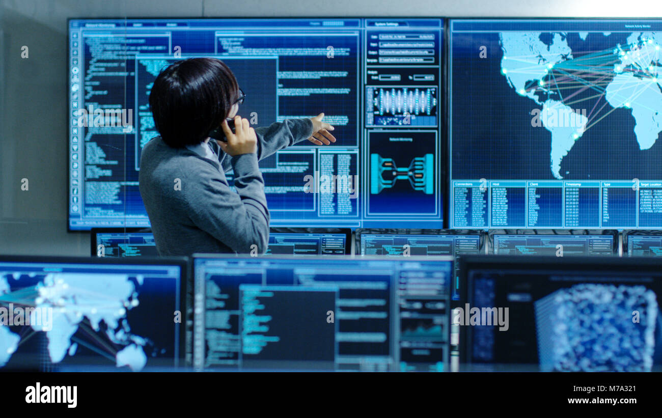 Nel sistema della sala di controllo Amministratore IT parla al telefono. Lui è in un impianto high-tech che lavora per la sorveglianza di reti neurali, dati Foto Stock