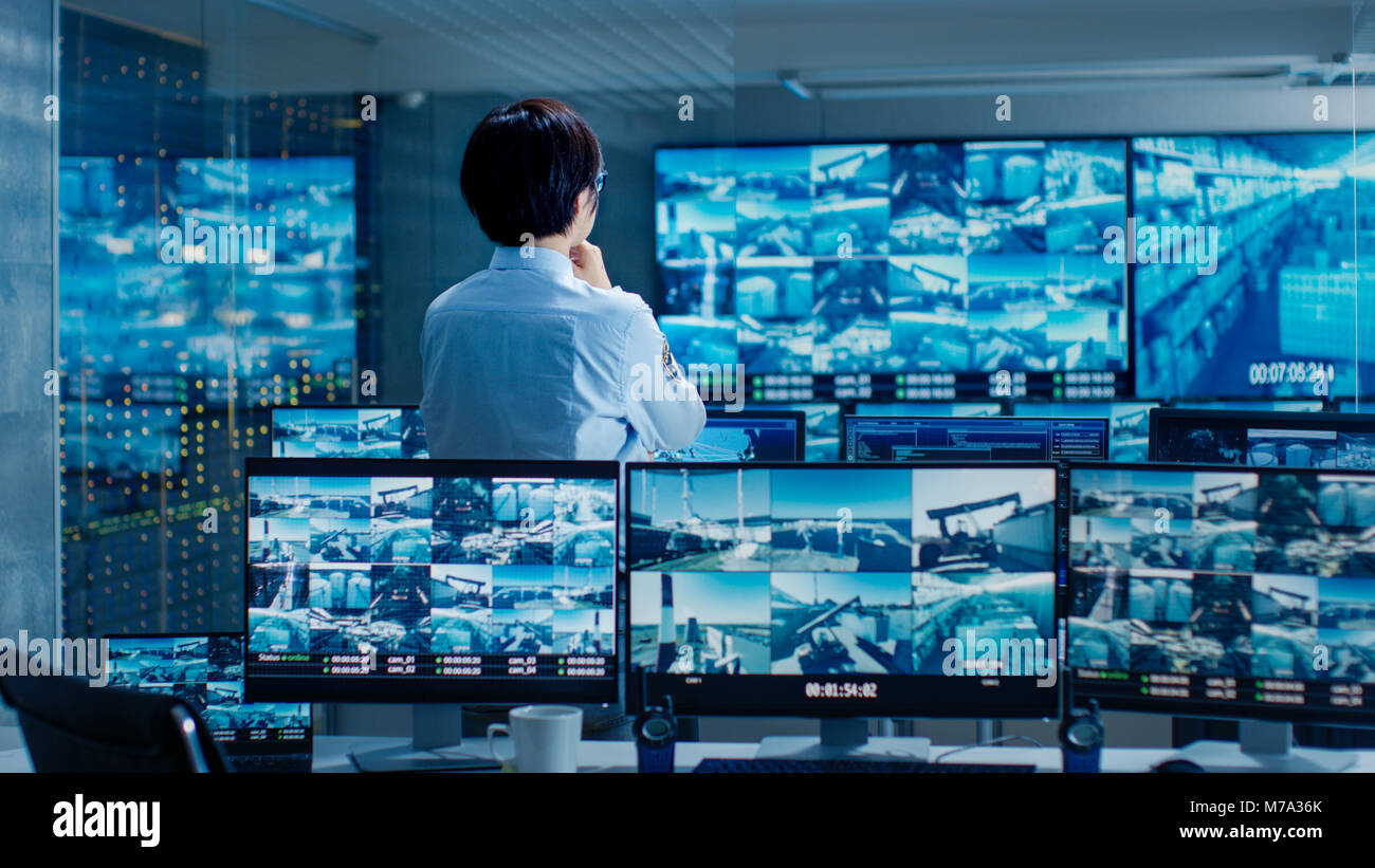 Nella sala di controllo per la sicurezza Officer i monitor di schermi multipli per attività sospette. Egli custodisce internazionalmente importante struttura logistica. Foto Stock