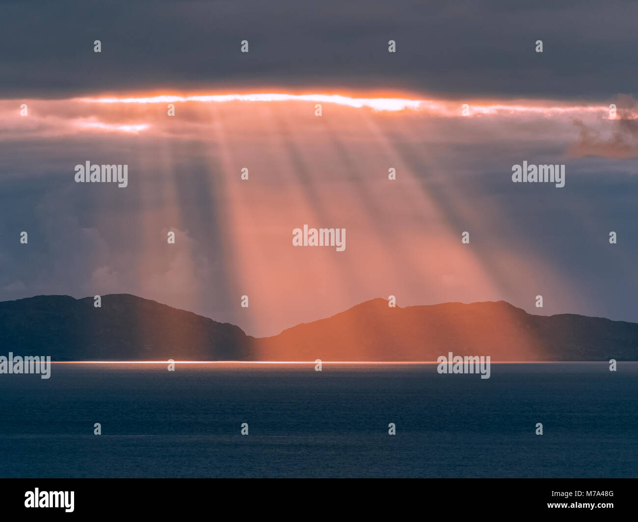 Maestoso tramonto sul Ebridi Esterne, come si vede dal punto Neist scogliera sull'Isola di Skye. I raggi di luce raggiante attraverso le nuvole scure. Foto Stock