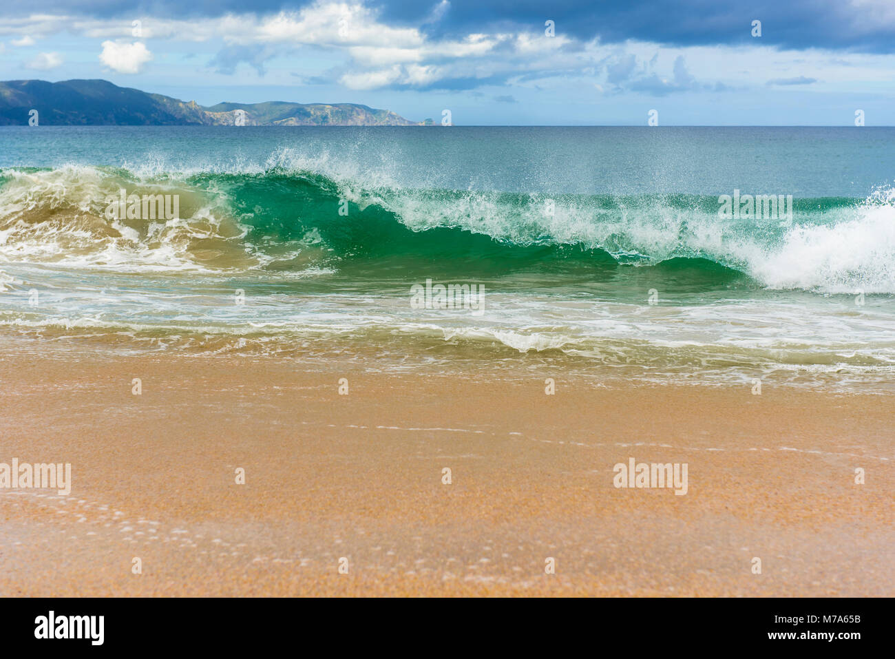 Le onde che si infrangono a spiriti Bay (Piwhane) con Cape Reinga a distanza, Isola del nord, Nuova Zelanda Foto Stock