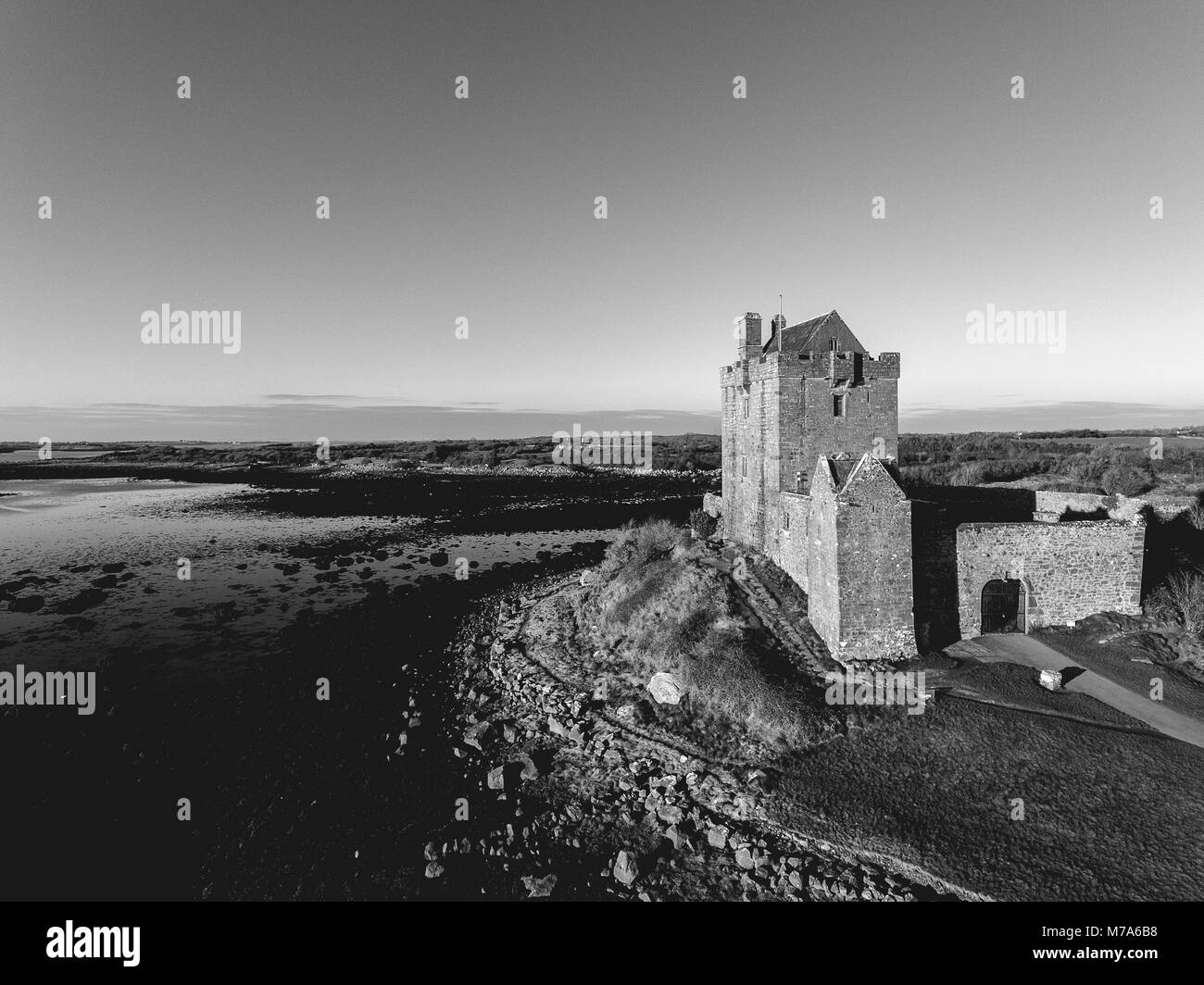 Bianco e nero Dunguaire Castle tramonto di sera, nei pressi di Kinvarra nella Contea di Galway, Irlanda - Atlantica selvaggia modo rotta. Pubblico famosa attrazione turistica mi Foto Stock