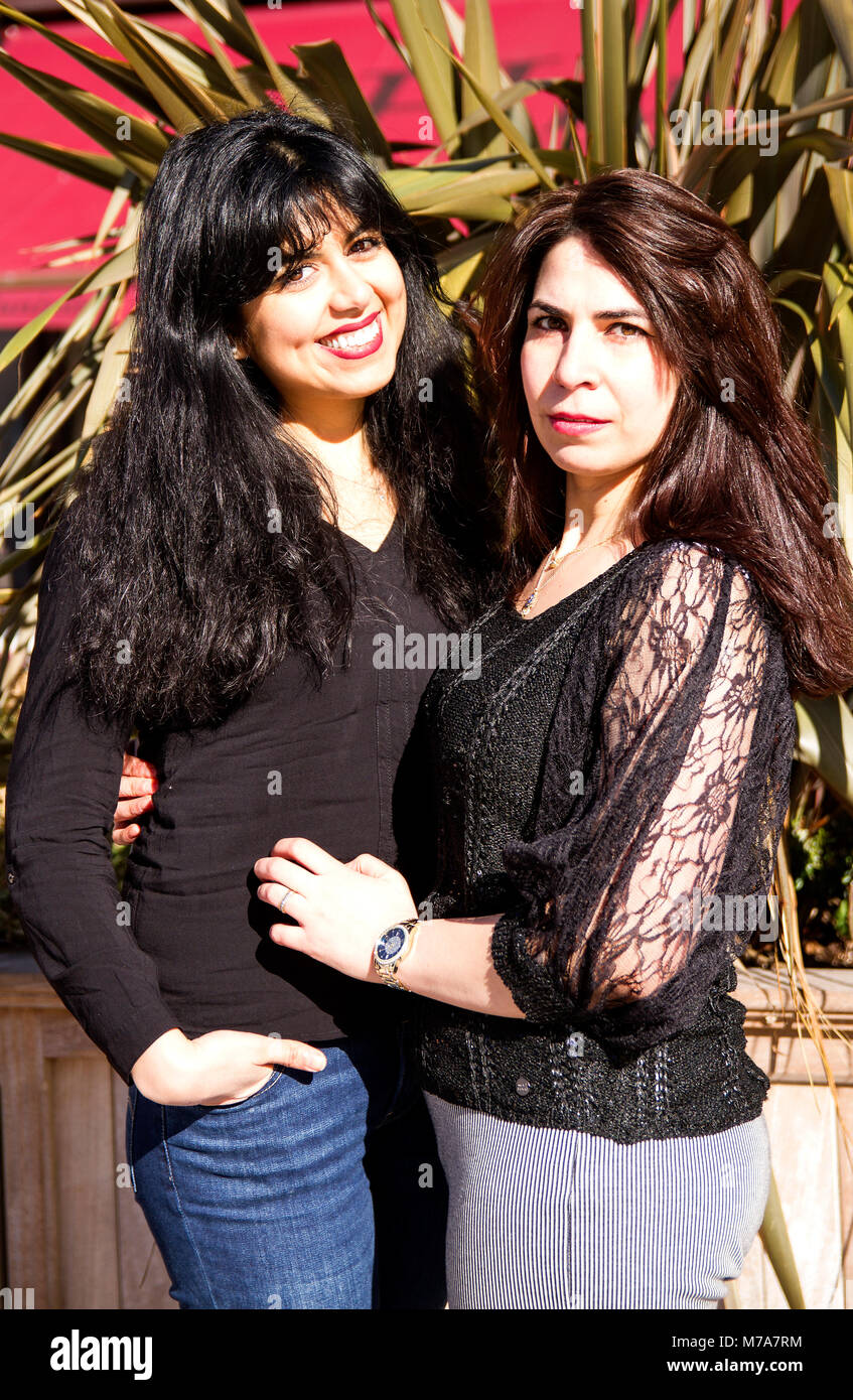 Due donne gli studenti universitari, Parisian-Algerian Faiza Faa (sinistra) e amico Samar Munaf dall'Iraq (destra) abbracciando permanente di ogni altro a Dundee, Regno Unito Foto Stock