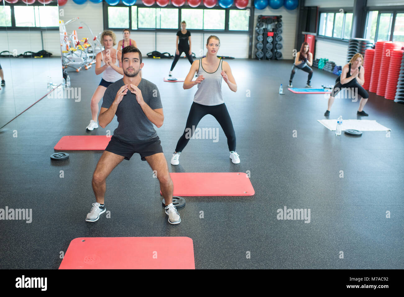 Palestra di persone facendo squat durante le lezioni di fitness Foto Stock