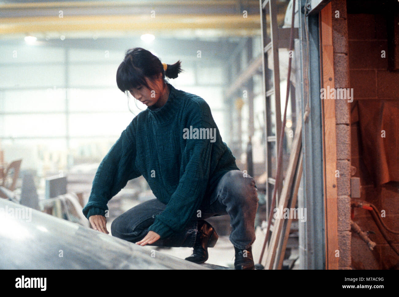 Maya Lin esaminando invertiti tavola di acqua essendo fabbricata per i diritti civili Memorial ha progettato per essere installato in Montgomery, Alabama. Essa è raffigurata qui presso il granito fabricater in barre, Vermont nel 1990. Foto Stock