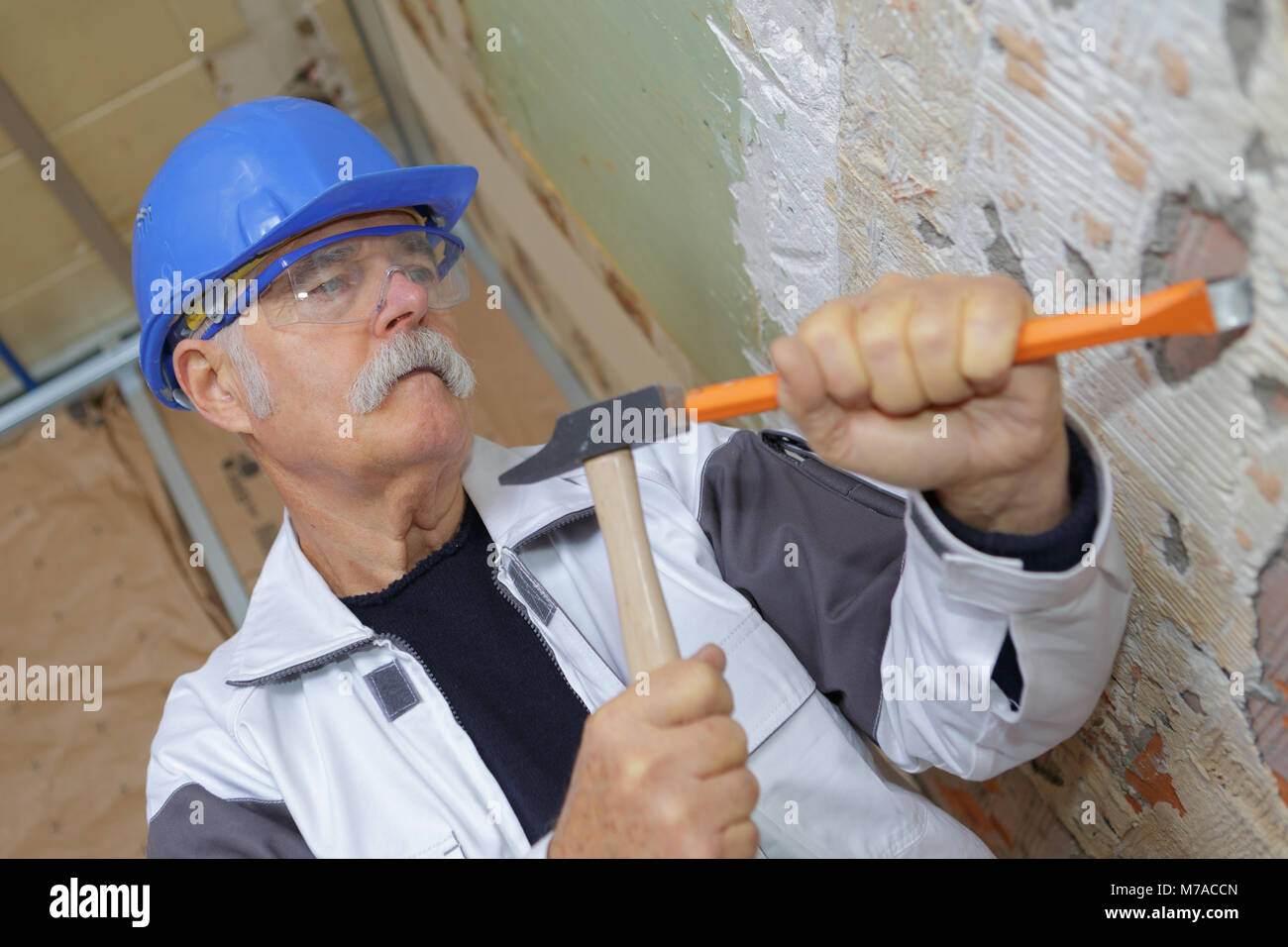 Senior falegname lavora con un martello e uno scalpello Foto Stock