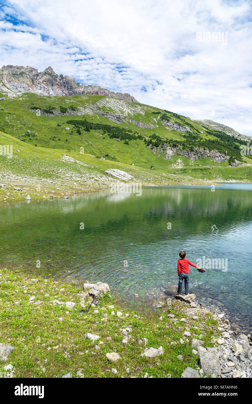 Austria Vorarlberg, Lechquellen montagne, Dalaas, piccolo ragazzo gioca sul Formarinsee Foto Stock