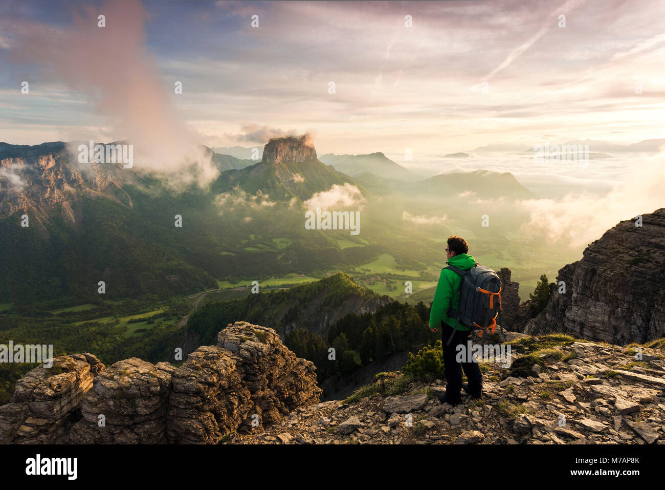 Escursionista con lontano dalla vista sul tramonto sul monte Aiguille, Dauphine, Francia Foto Stock