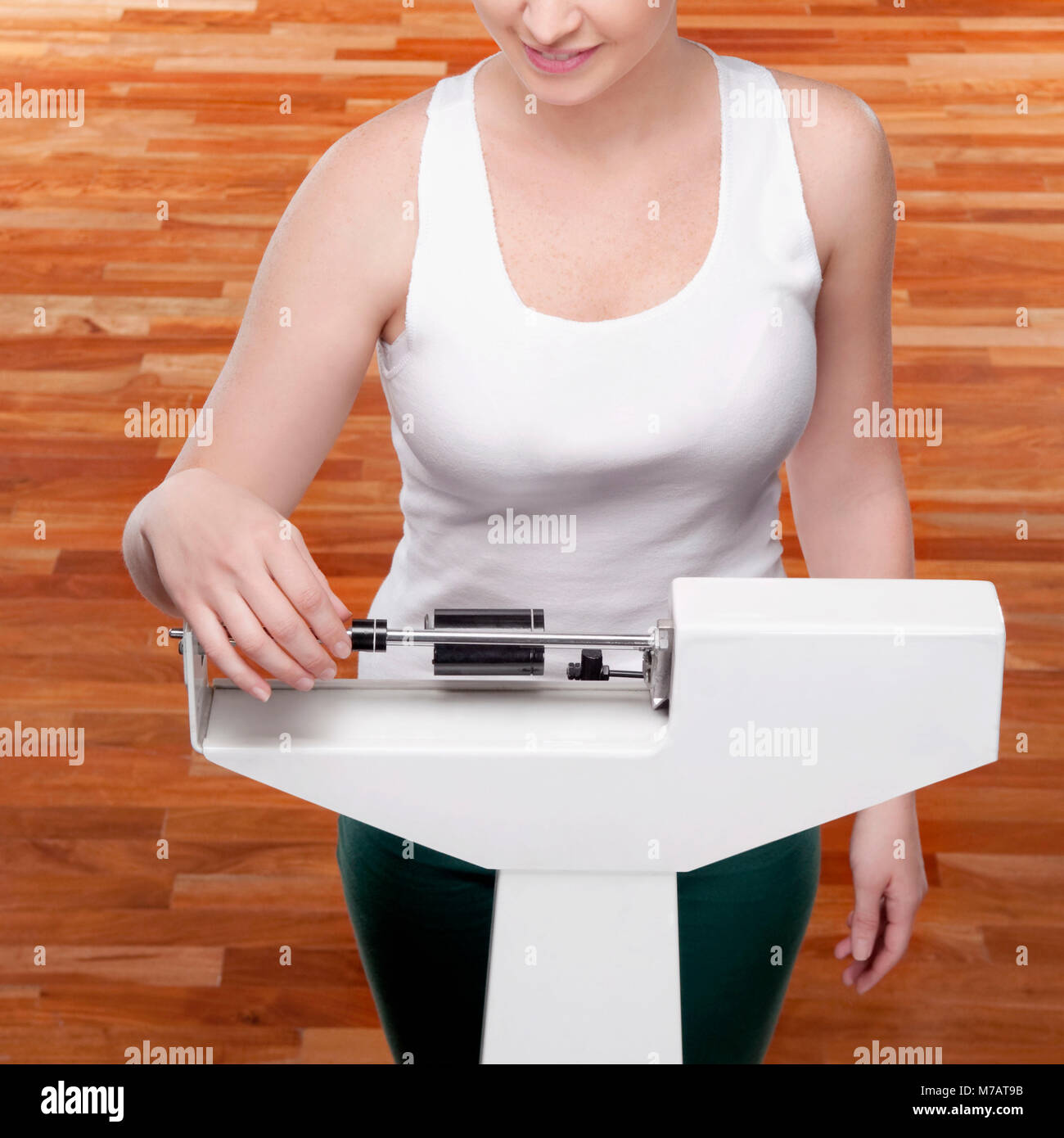 Donna misurando il suo peso su una bilancia di pesatura Foto Stock