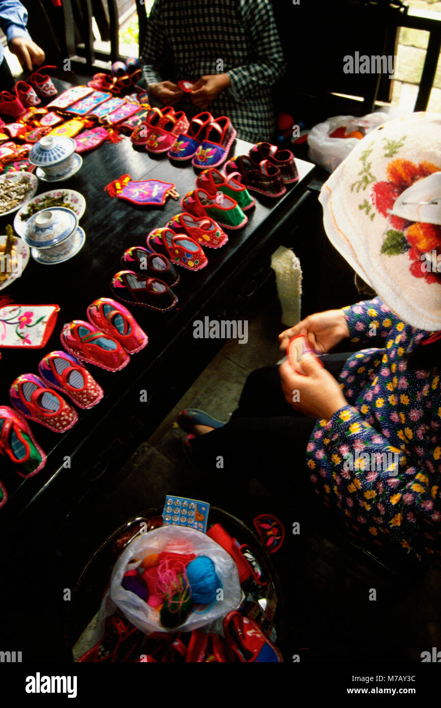 Angolo di alta vista di tre donne la cucitura baby scarpine, Zhouzhuang, Kunshan Città, provincia dello Jiangsu, Cina Foto Stock