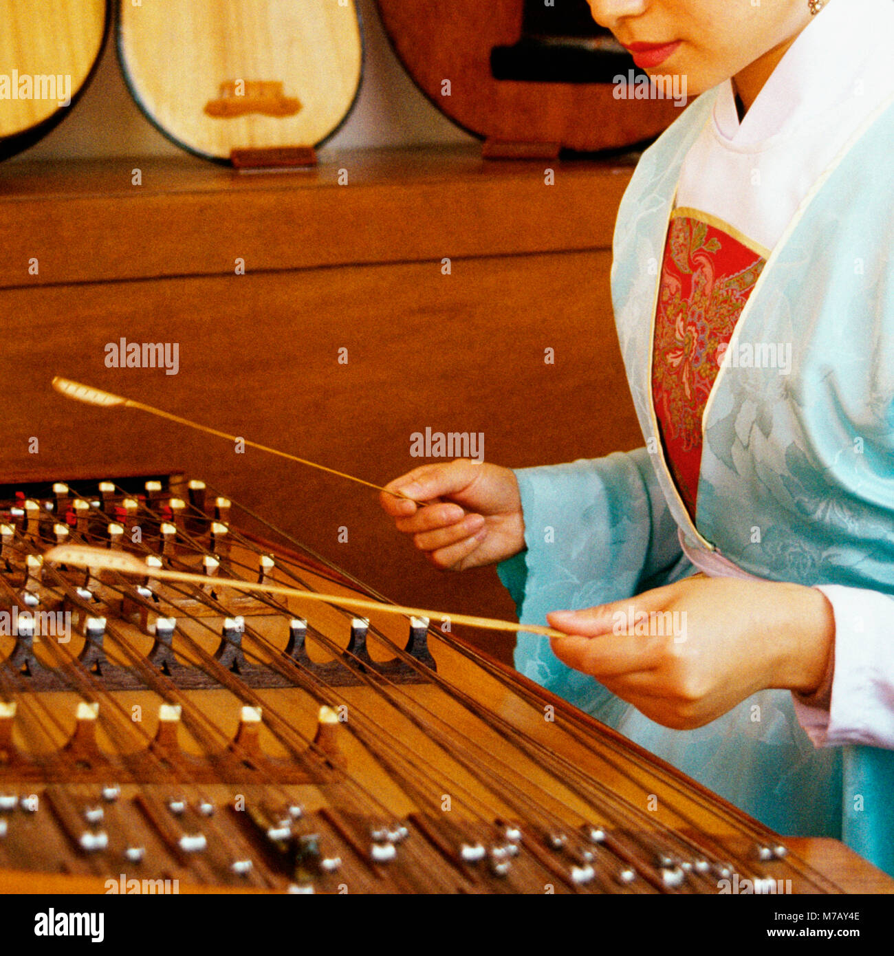 Il profilo laterale di una giovane donna che gioca dulcimer, Hong Kong, Cina Foto Stock