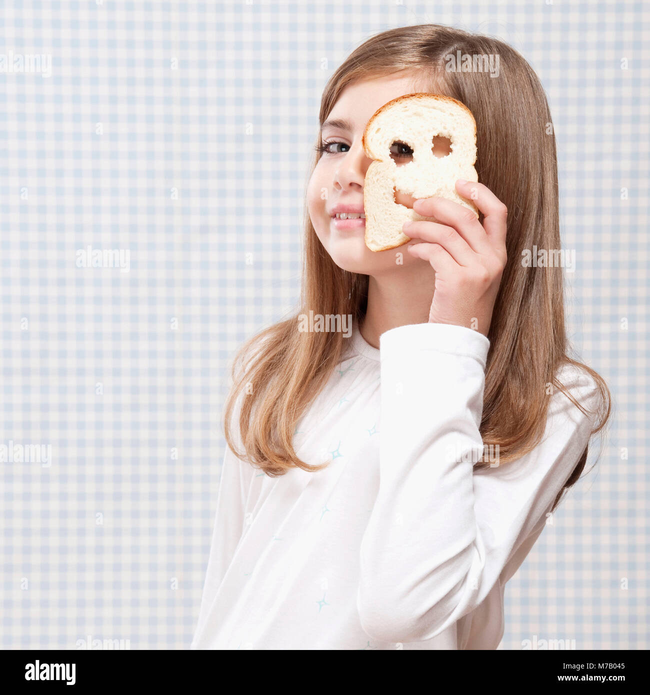 Ragazza con una fetta di pane con faccina sorridente Foto Stock