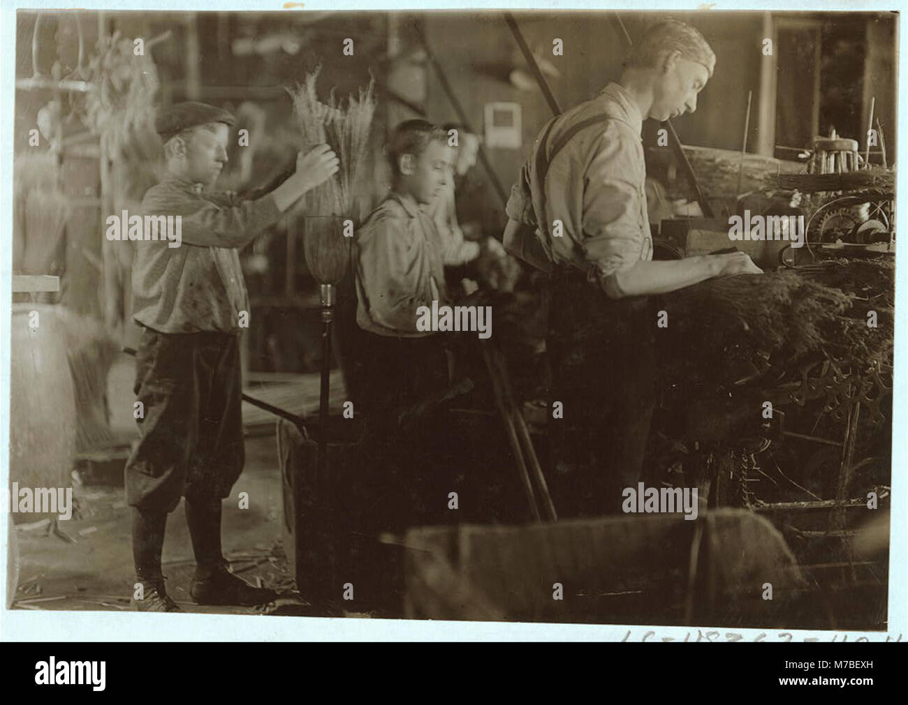 Questa fotografia mostra i ragazzi che lavorano presso la S.W. Brown Manufacturing Company, che assistono nella fabbricazione di spazzatrici. Riflette le pratiche del lavoro minorile in contesti industriali durante i primi anni del XX secolo. Foto Stock