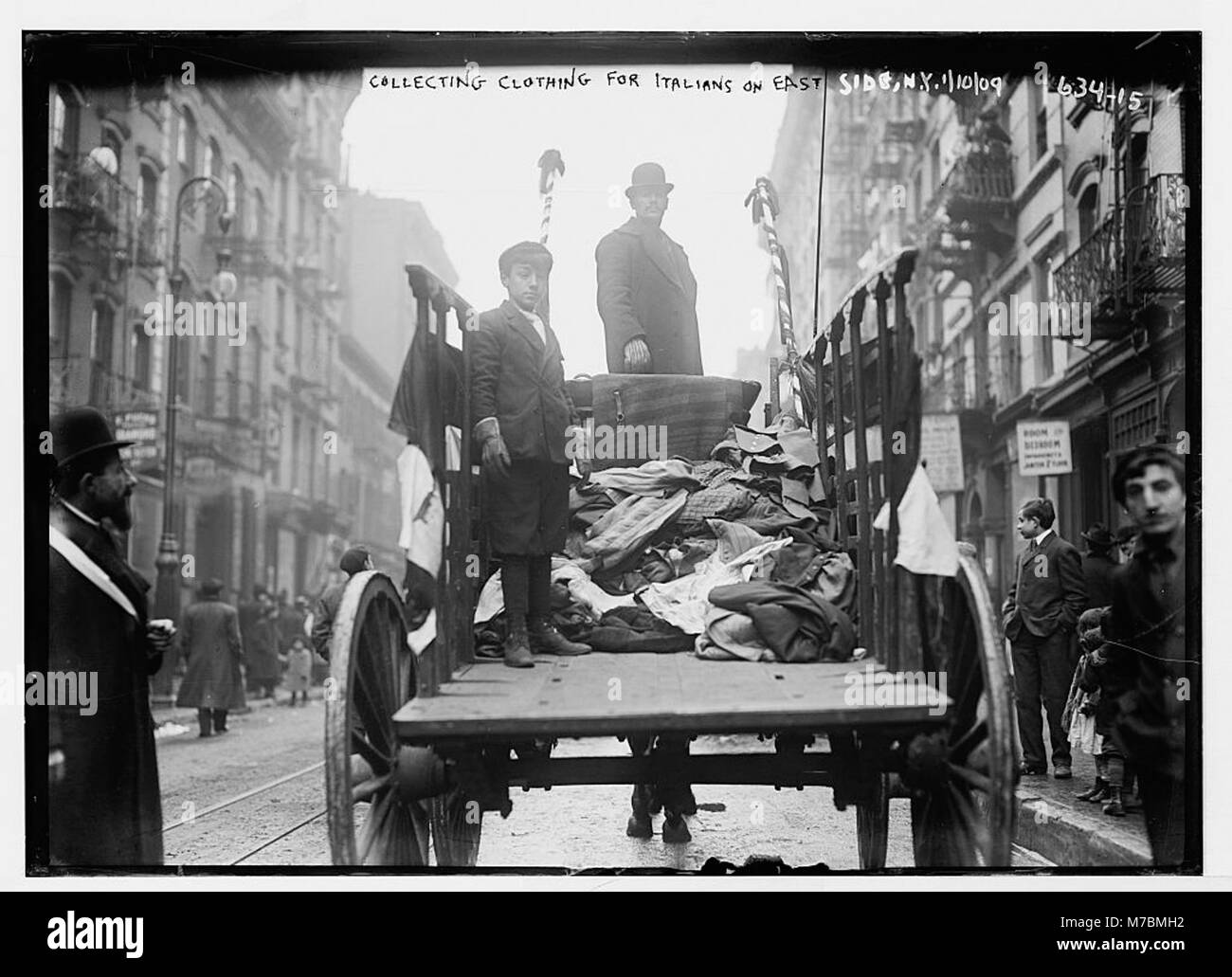 Un carro di vestiti sul lato est di New York, che fornisce merci agli immigrati italiani. Questa immagine riflette l'integrazione delle comunità culturali attraverso il commercio e il commercio. Foto Stock