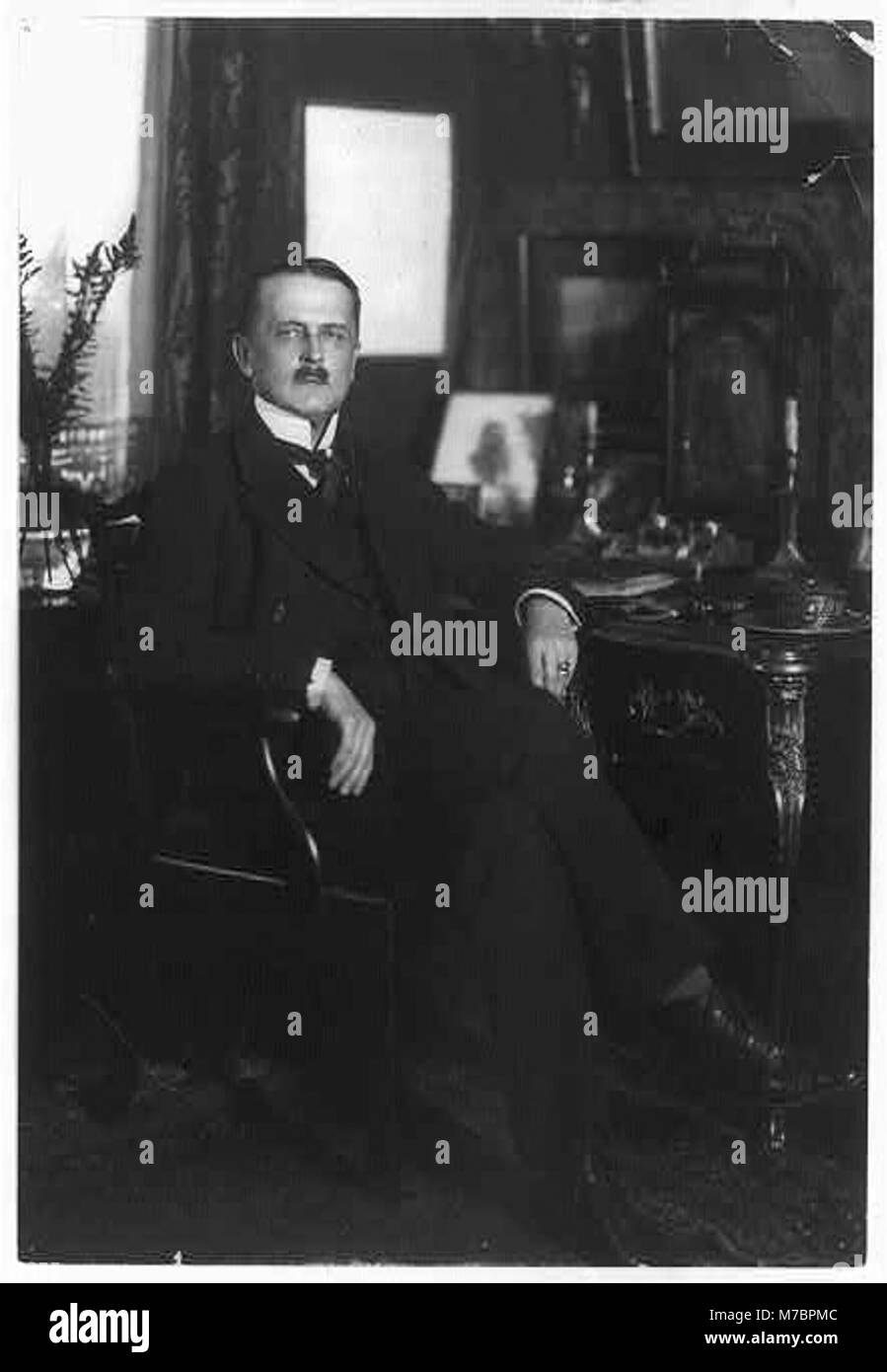 Un ritratto a figura intera del conte Brockdorff-Rantzau, una figura di spicco della diplomazia europea durante la prima guerra mondiale, seduto a una scrivania, che riflette il suo ruolo nelle relazioni internazionali durante l'inizio del XX secolo. Foto Stock