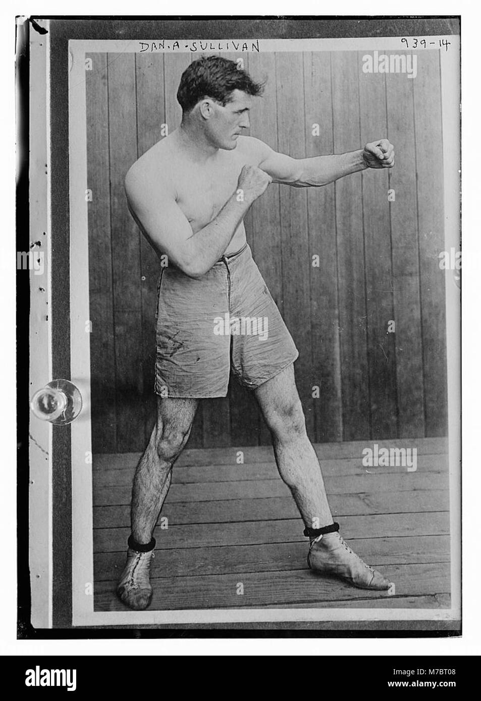 Dan A. Sullivan viene catturato in una posa di boxe, mostrando la sua posizione atletica e la sua disponibilità all'azione. L'immagine mette in evidenza la sua forza e la sua concentrazione nello sport della boxe. Foto Stock