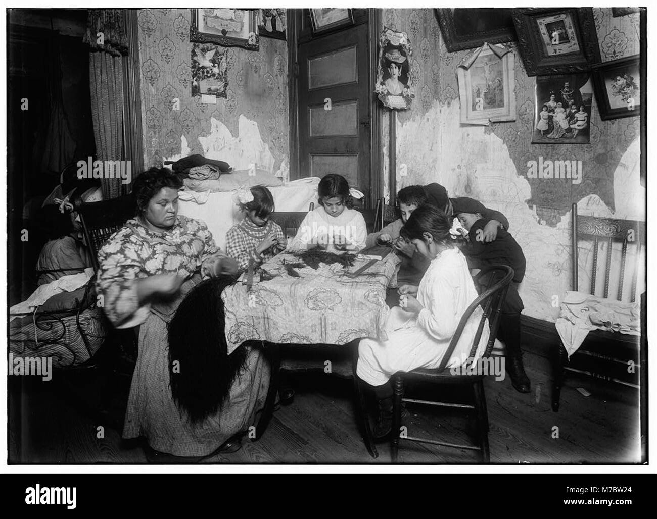 Questa fotografia raffigura la vita quotidiana di una famiglia che lavora sulle piume nella loro casa al 309 E. 110th St. A New York. La famiglia guadagnava 2,25 dollari a settimana, e durante le vacanze, guadagnava di più. I bambini, tra cui Victoria, 8 anni, e Angelina, 10 anni, sono coinvolti nell'attività. Foto Stock