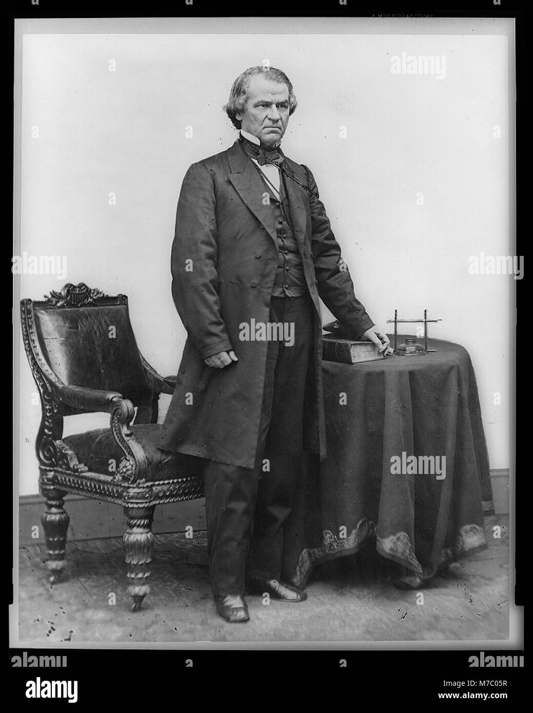 Questo ritratto a figura intera di Andrew Johnson, il diciassettesimo presidente degli Stati Uniti, lo mostra in piedi accanto a un tavolo e a una sedia, dando un'occhiata al suo comportamento presidenziale e alla sua presenza storica durante la sua amministrazione. Foto Stock