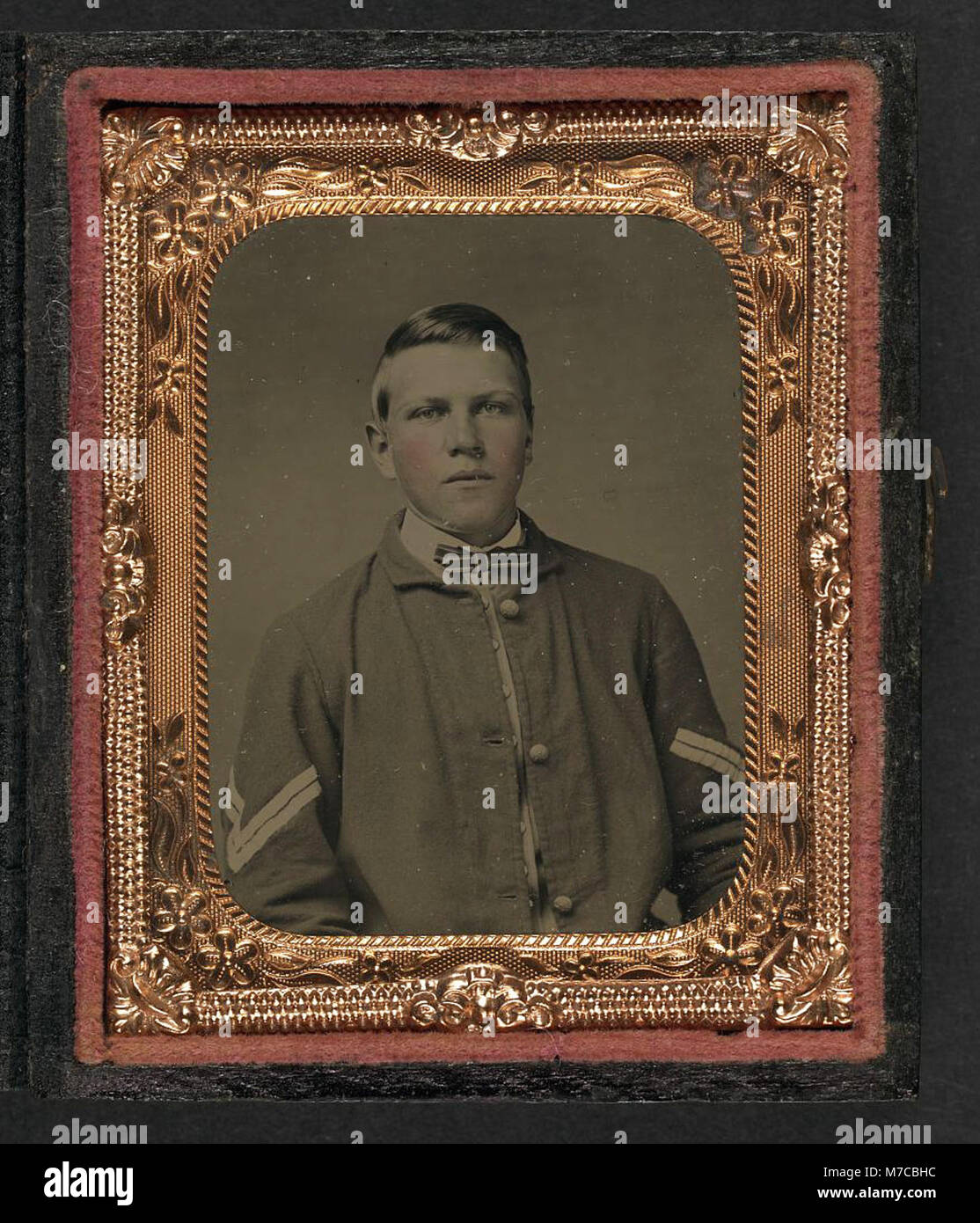 Un ritratto di un giovane soldato non identificato che indossa l'uniforme di un caporale dell'Unione durante la guerra civile americana. L'immagine rappresenta la giovinezza e l'impegno dei soldati durante il conflitto. Foto Stock