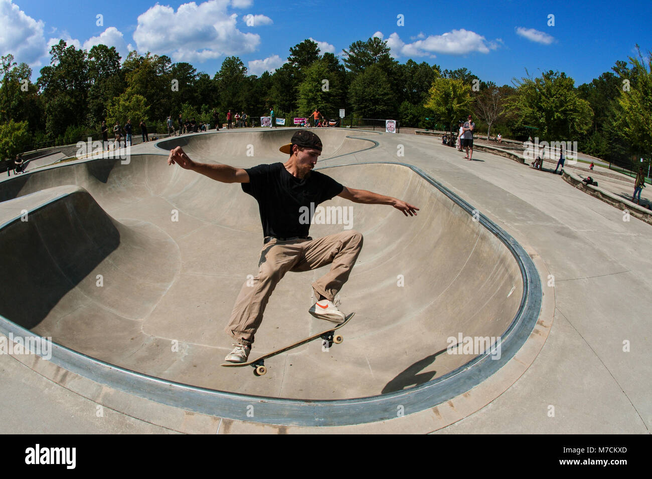 Un giovane uomo esegue un midair skateboard trick in skateboard di coppa a ponte si assesta Park in Suwanee GA, 16 settembre, 2017. Foto Stock