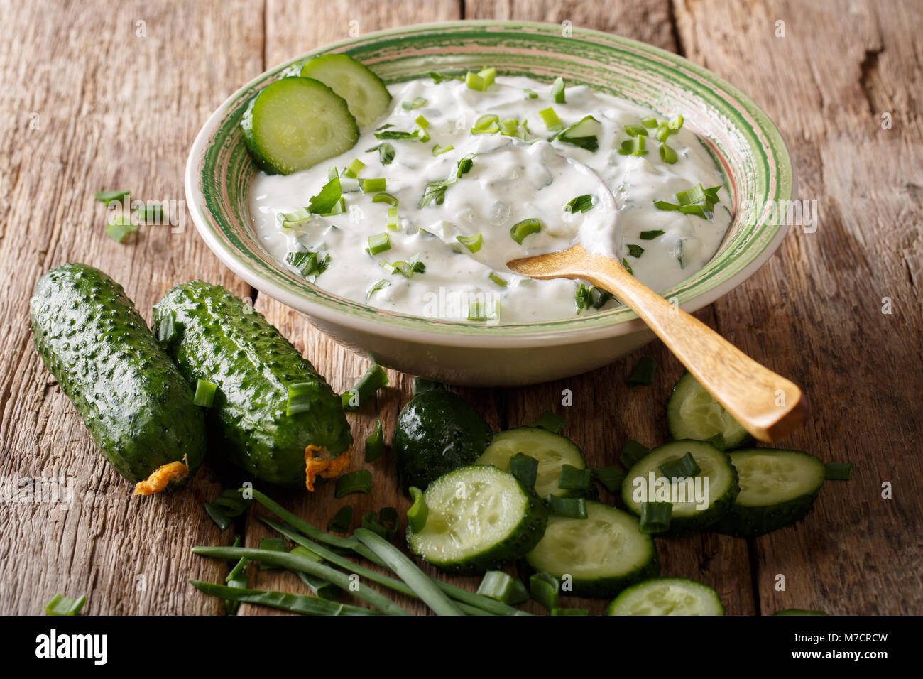 Raita salsa di yogurt con erbe aromatiche, spezie e il cetriolo close-up in una ciotola sul tavolo orizzontale. Foto Stock