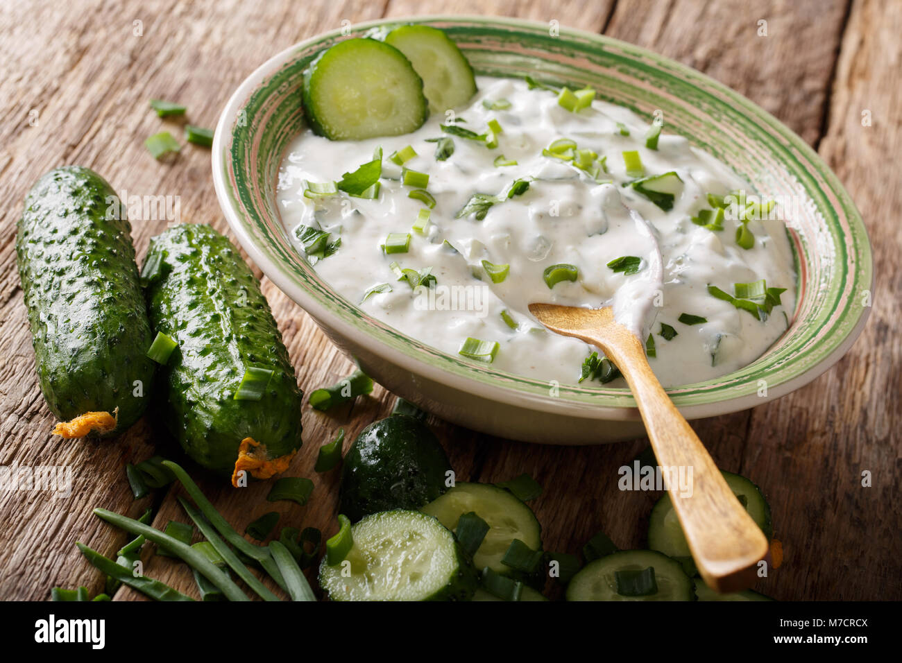 Salsa di yogurt con erbe aromatiche, spezie e il cetriolo close-up in una ciotola sul tavolo. raita orizzontale. Foto Stock