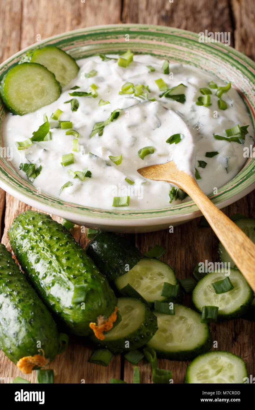 Indian salsa piccante raita con erbe e il cetriolo close-up in una ciotola sul piano verticale. Foto Stock