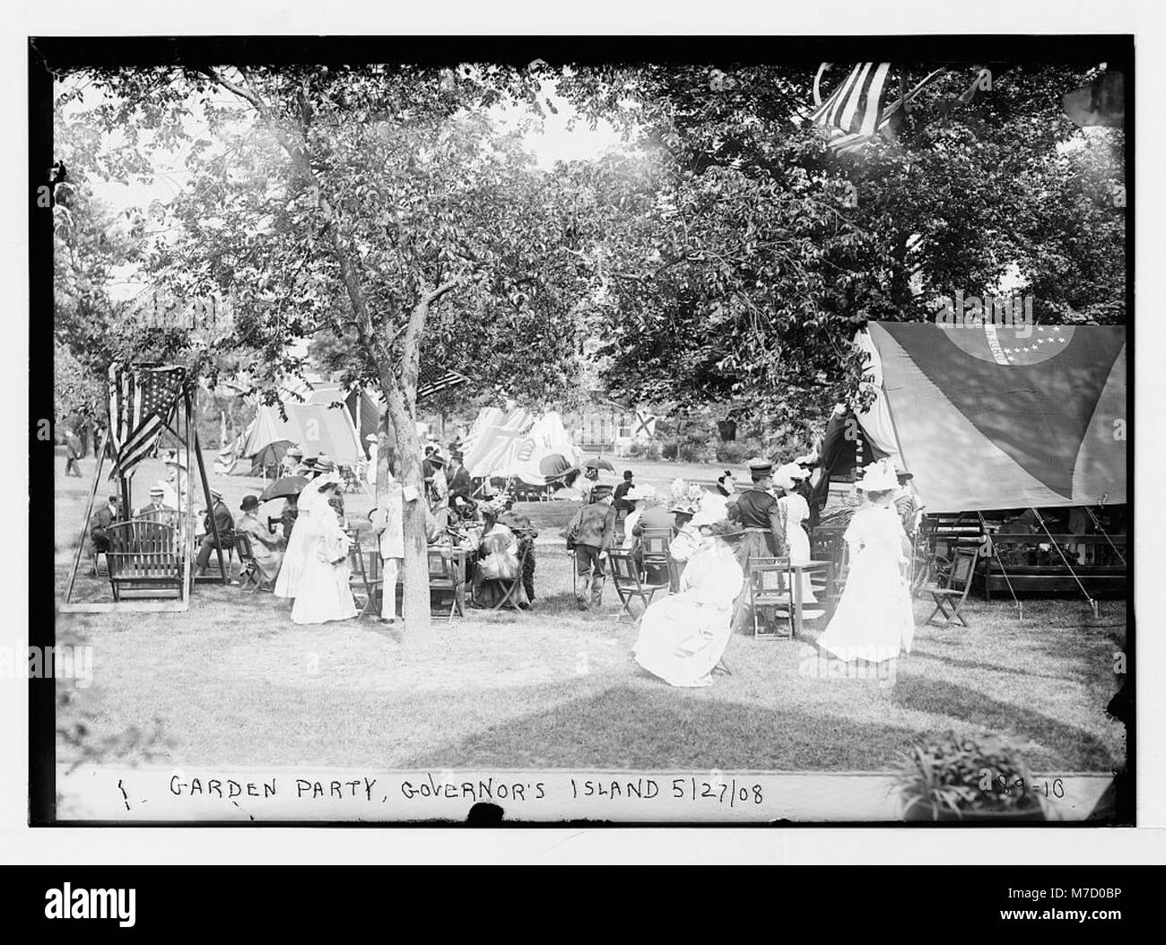 Una fotografia di una festa in giardino che si svolge a Governor's Island, New York, che mostra l'ambiente all'aperto e il ritrovo sociale. Foto Stock