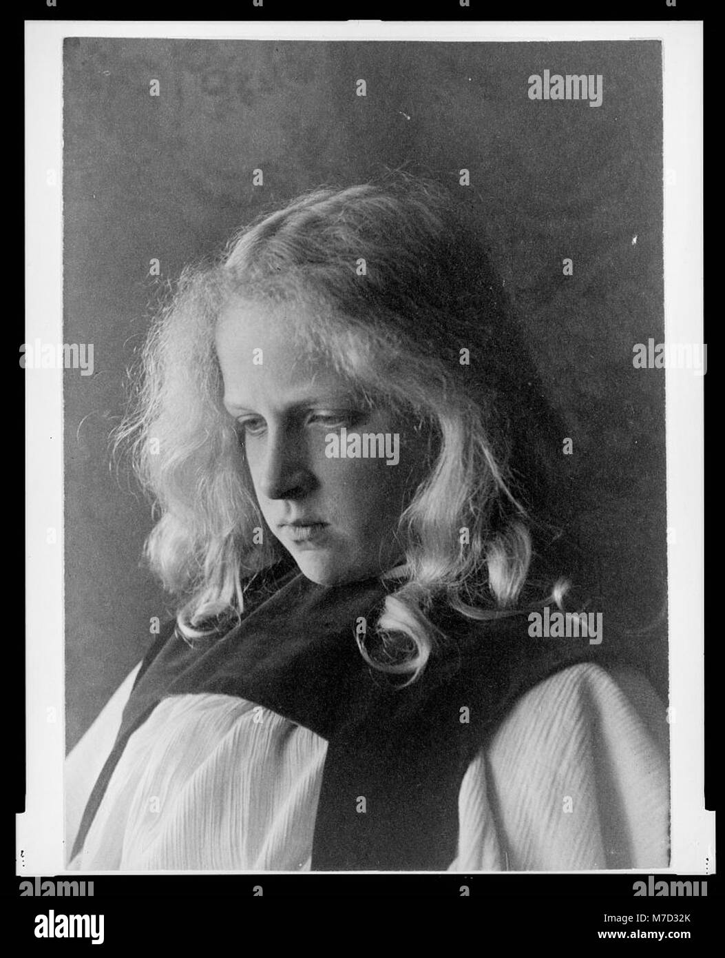 Ritratto di una ragazza in abito bianco con colletto nero, che cattura un momento di serena eleganza. La fotografia riflette l'abbigliamento e gli stili dei primi anni del XX secolo. Foto Stock