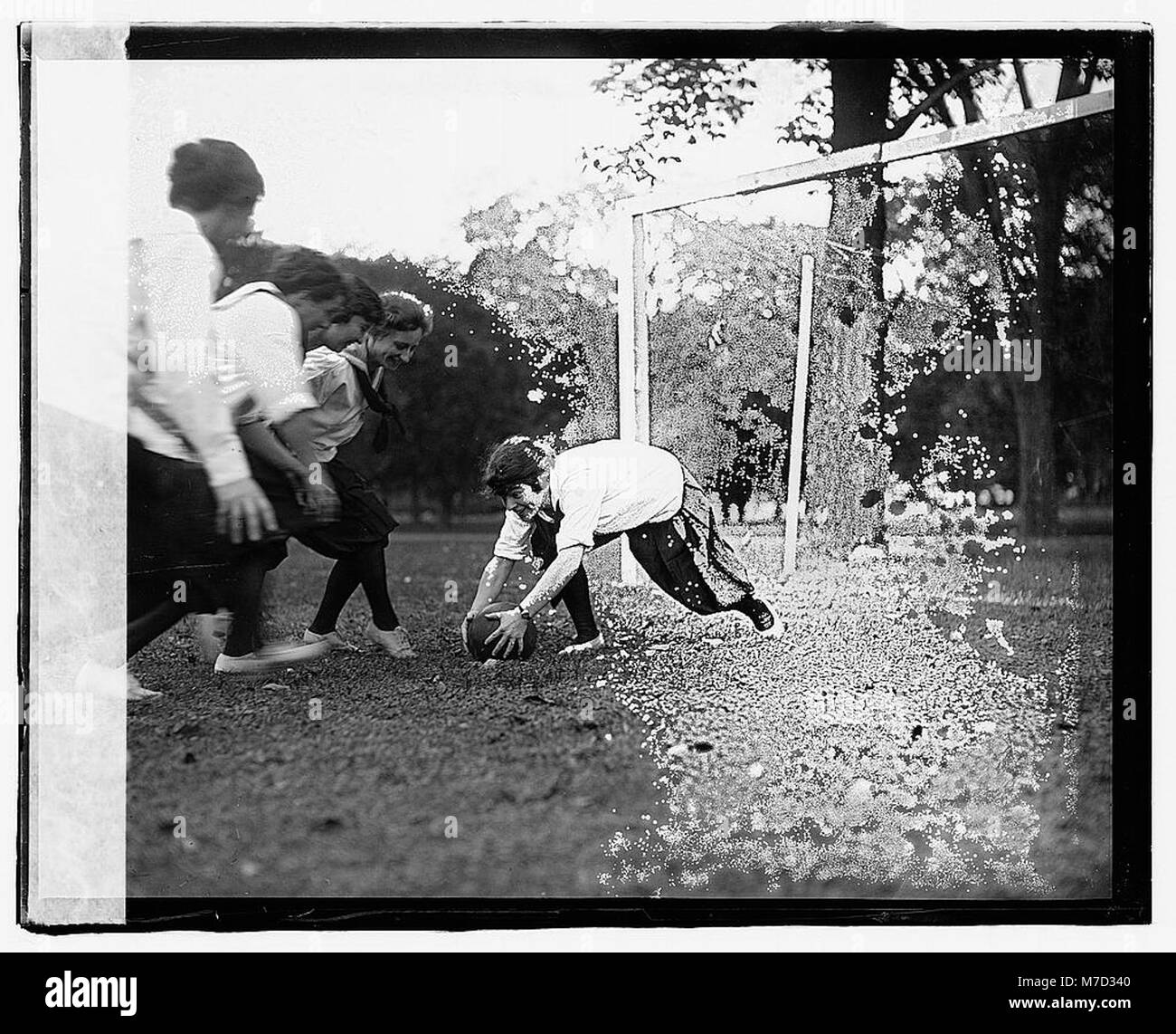 Una fotografia che cattura una ragazza che gioca a calcio, evidenziando la sua partecipazione allo sport. L'immagine riflette la crescente inclusione delle donne nelle attività sportive e nella cultura sportiva. Foto Stock