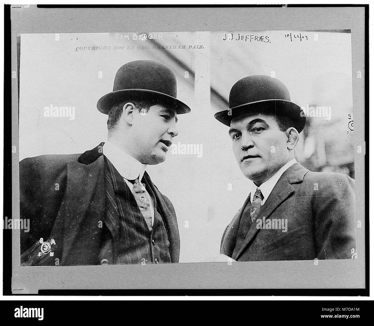 Ritratto di James J. Jeffries, l'ex campione di pugilato dei pesi massimi, raffigurato in profilo mentre ascoltava Sam Berger, il suo manager. L'immagine evidenzia la statura di Jeffries e il suo legame con Berger nel mondo della boxe. Foto Stock