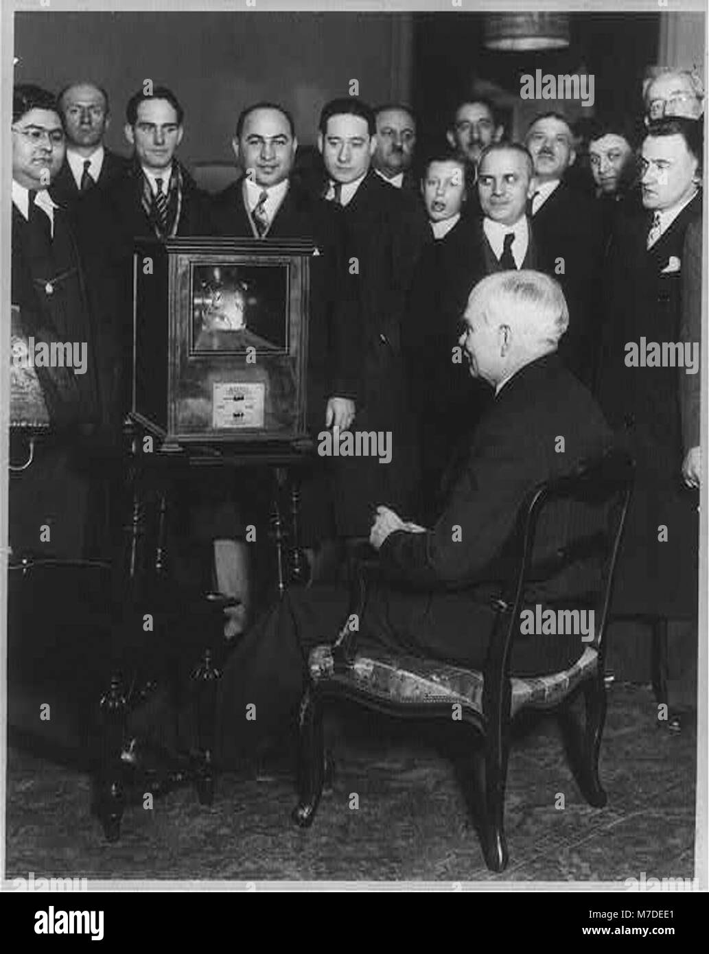 Questo ritratto a figura intera mostra Lee DeForest, una figura chiave dell'elettronica e della radio, seduto di fronte a una piccola folla mentre osserva un film parlante di se stesso a Newark, New Jersey. Foto Stock