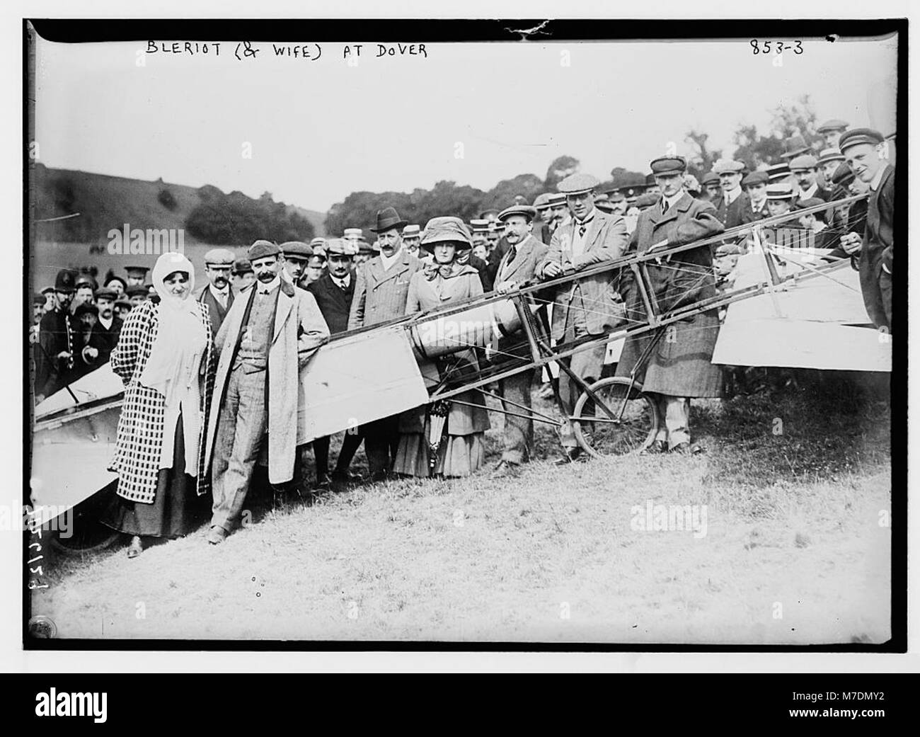 Una fotografia storica del signor e della signora Bleriot, pionieri dell'aviazione, in piedi accanto al loro aereo in un campo a dover, circondato da una folla, che cattura un momento nella storia dell'aviazione. Foto Stock