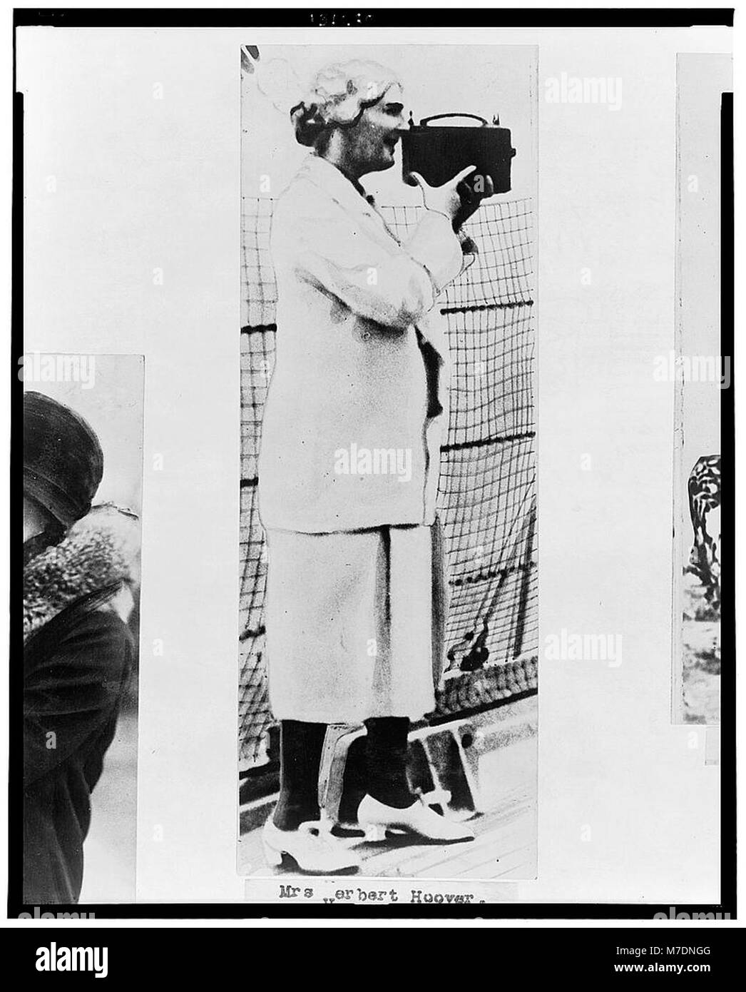 Un ritratto a figura intera della signora Herbert Hoover, membro della White House News Photographers Association, che tiene una macchina fotografica sul suo volto. È rivolta a sinistra nella fotografia. Foto Stock