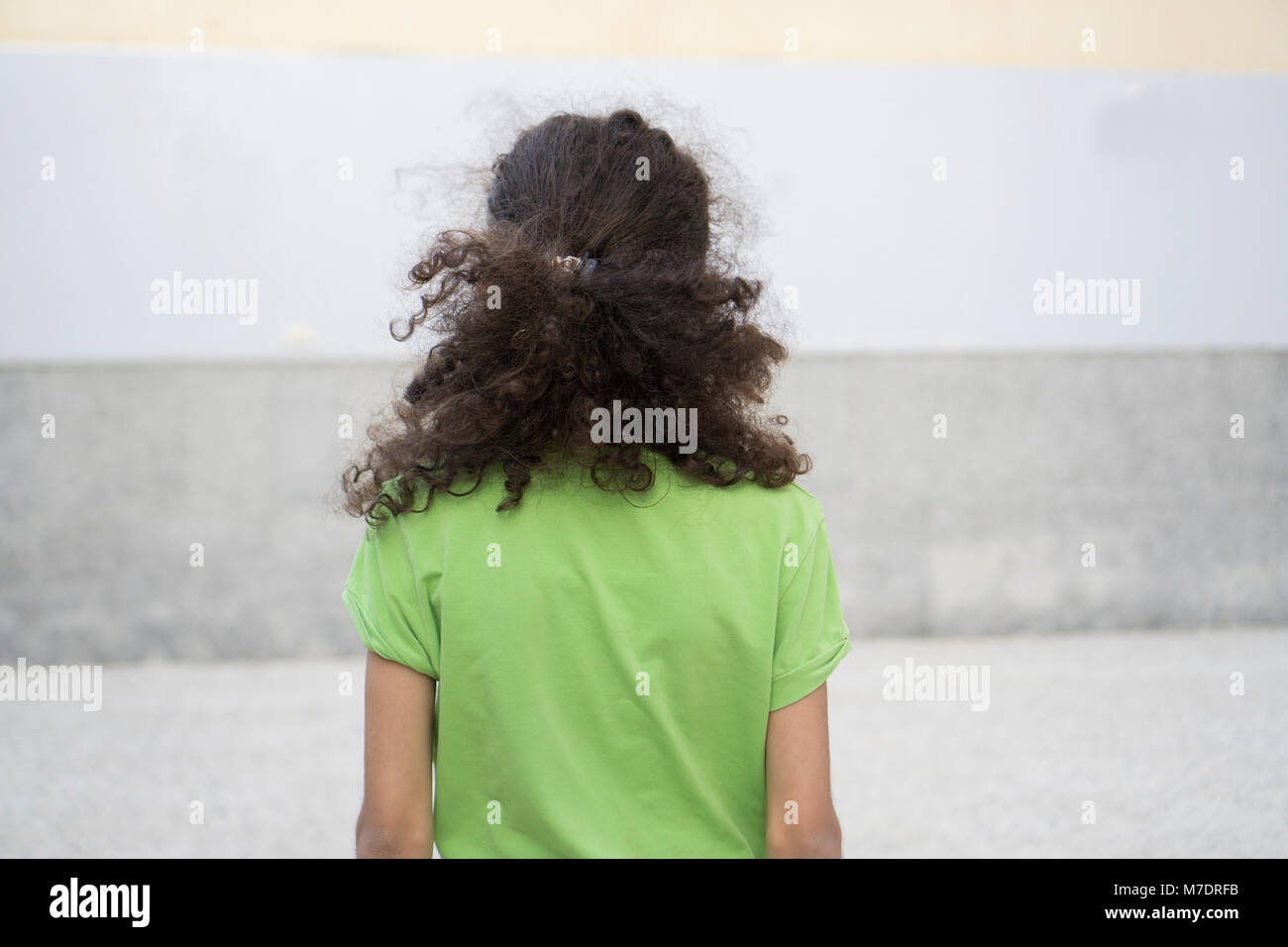 Vista Reare di 12 anni ragazza con scuri capelli ricci Foto Stock
