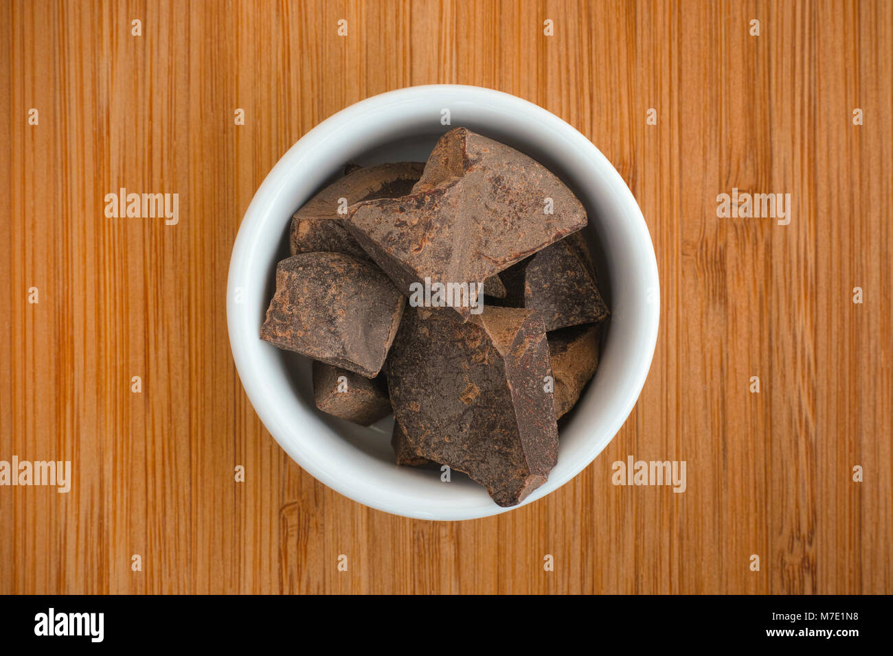 Organici di pasta di cacao in un recipiente su un sfondo di legno. Close up. Foto Stock