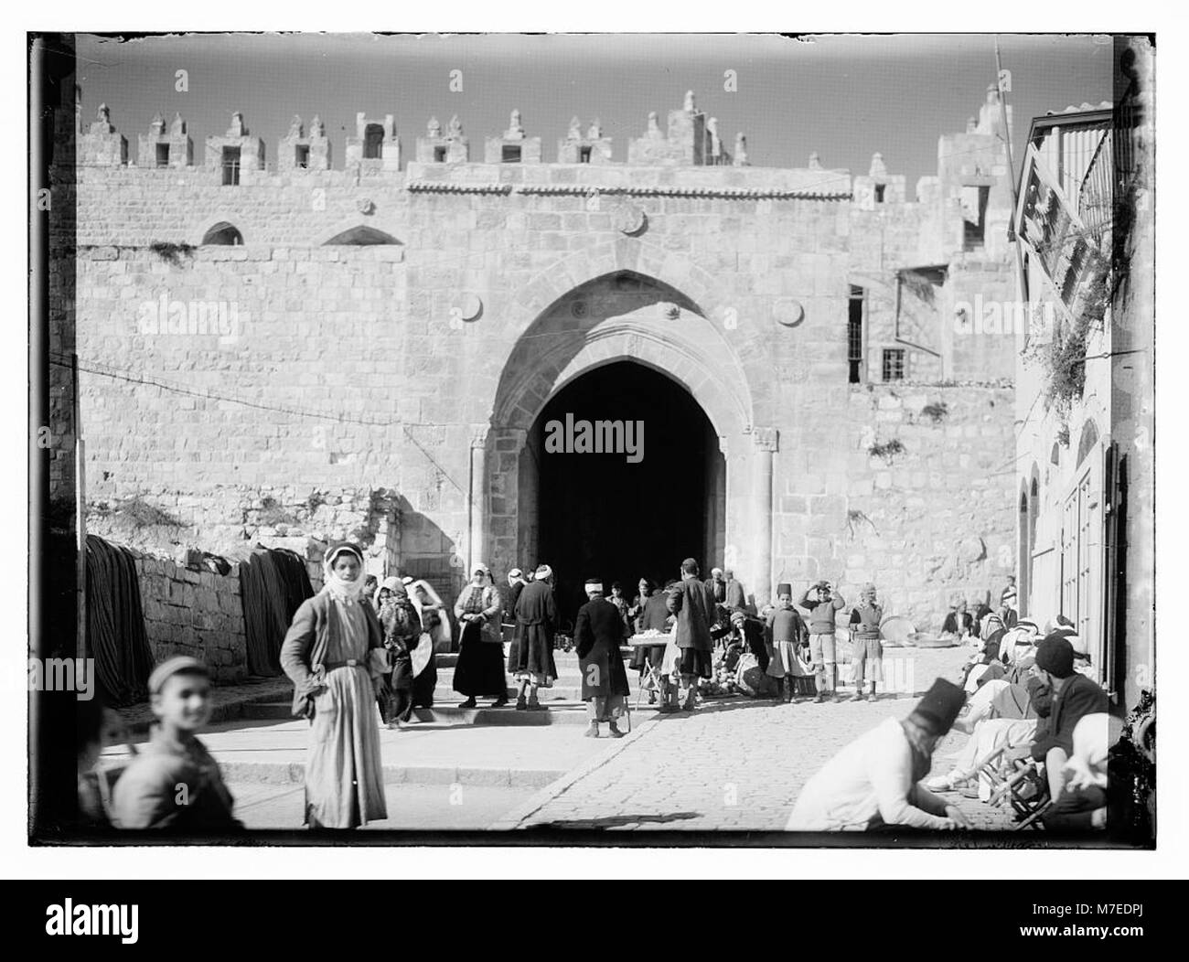 Questa immagine cattura persone e venditori alla porta di Damasco a Gerusalemme, un sito storico significativo per la sua importanza religiosa, culturale e storica. Foto Stock