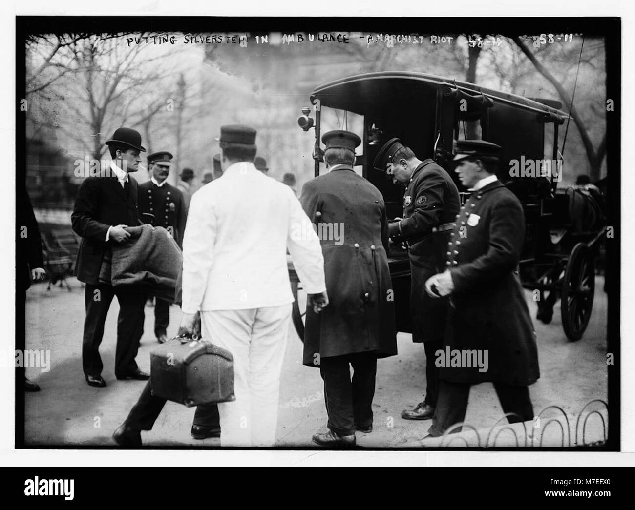 Un poliziotto assiste Silverstein in un'ambulanza trainata da cavalli durante una rivolta anarchica a Union Square a New York, catturando un momento di disordini civili. Foto Stock