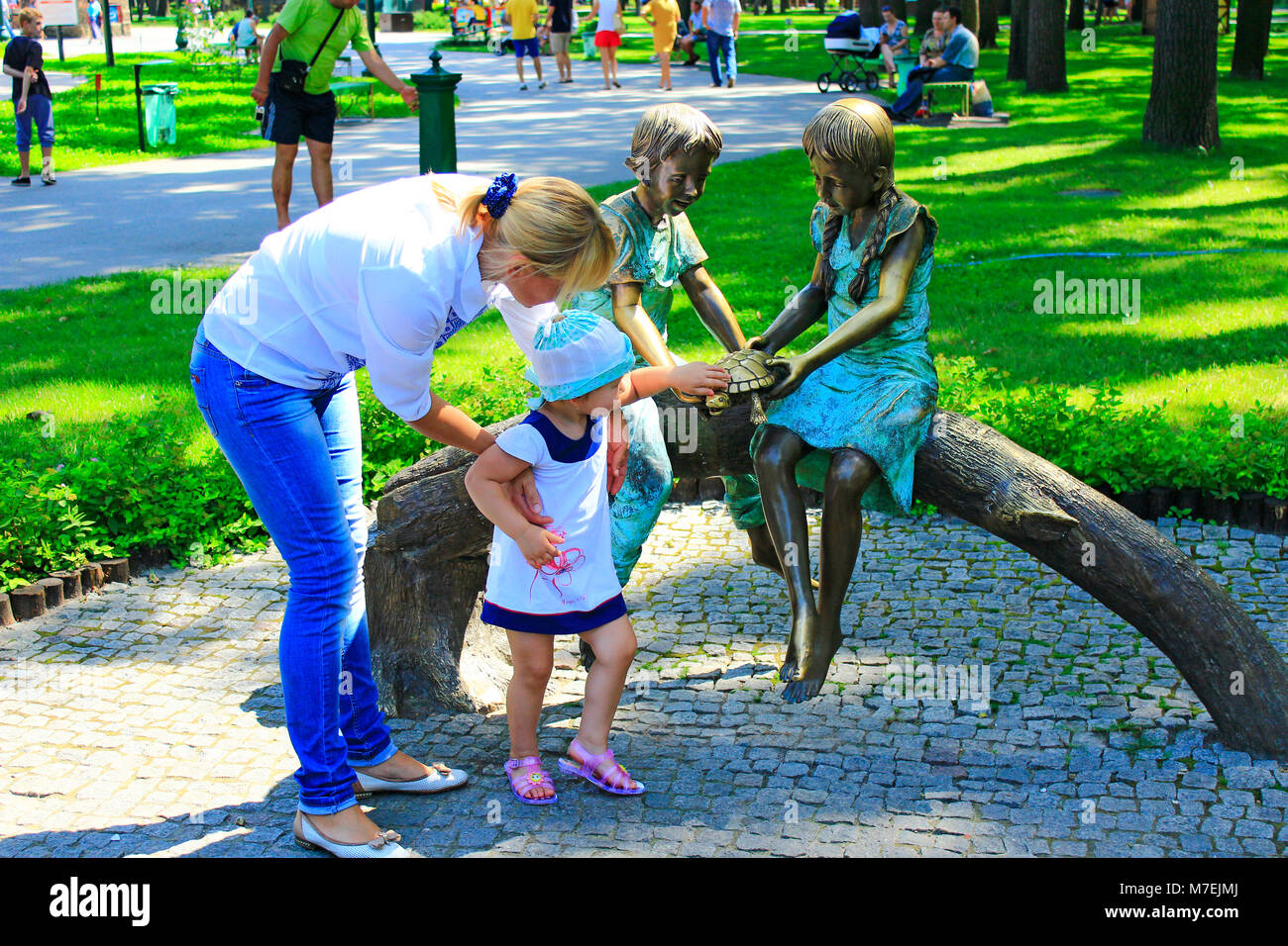 Madre con sua figlia vicino matallic Scultura nel parco della città Foto Stock