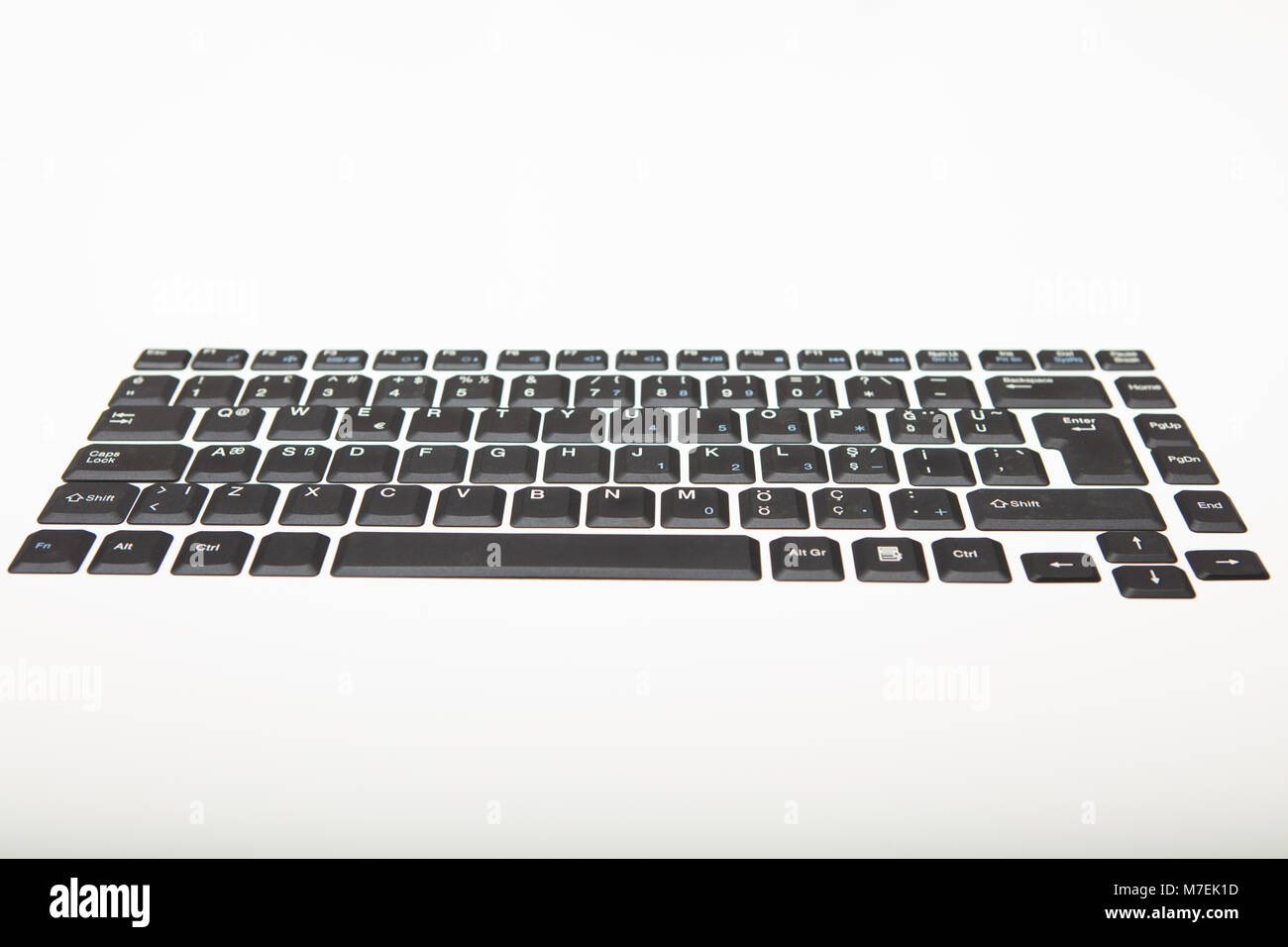 Basso angolo vista di una alfanumerica QWERTY computer tastiera con tasti neri su gradiente di argento al bianco con copia spazio sopra Foto Stock