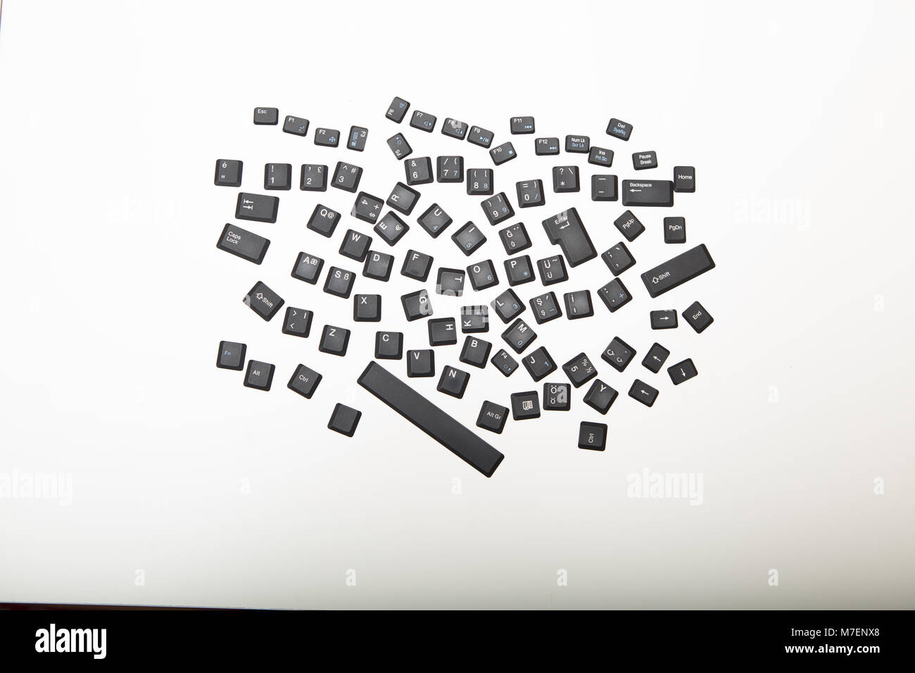 Allentati i coperchi alfanumerico per i tasti sulla tastiera di un computer in un guazzabuglio casuale su un bianco o argento chiaro sfondo visto dal sovraccarico ho centrato Foto Stock