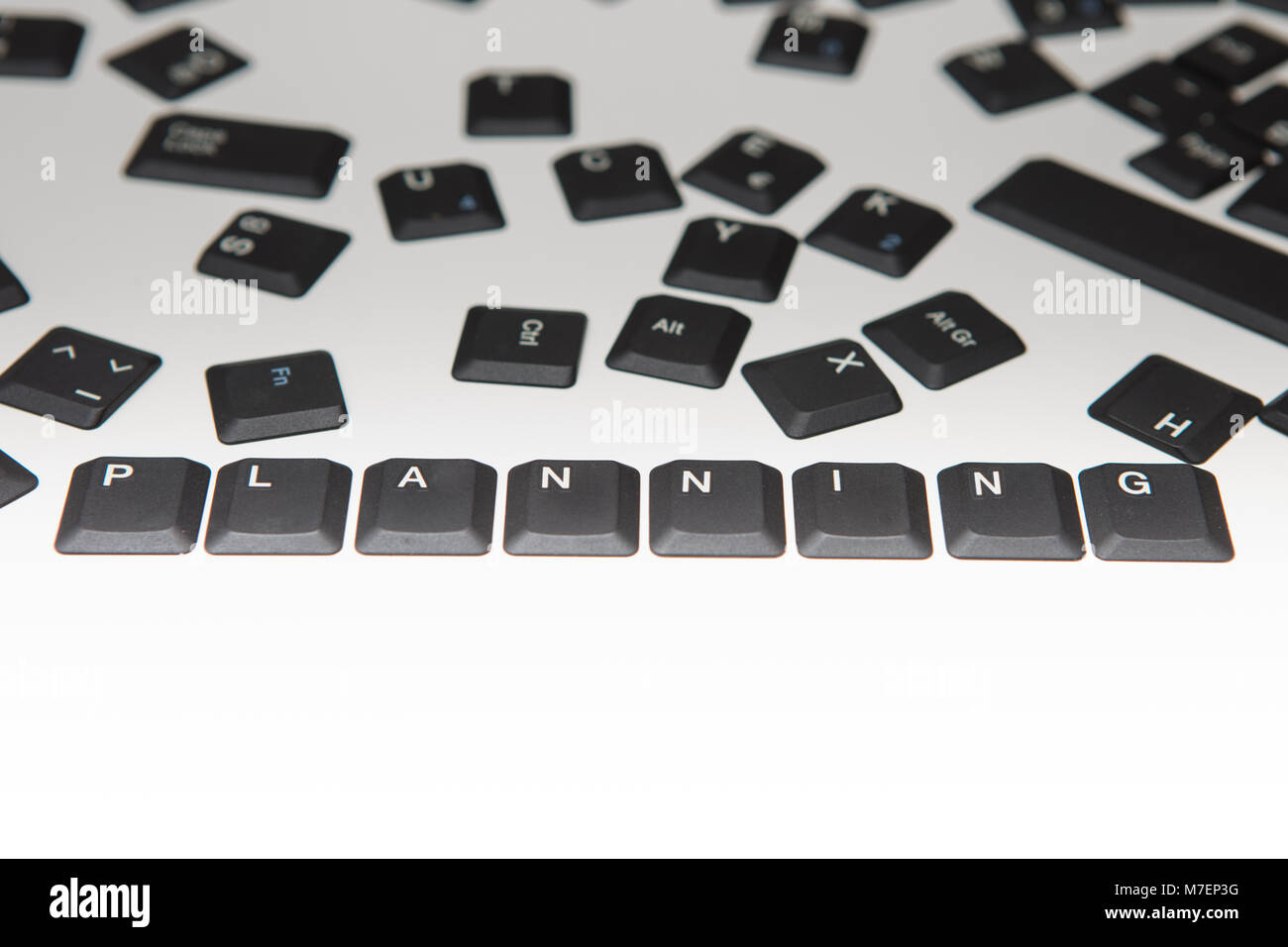 Allentate alfanumerico sparsi e il tasto funzione copre da un computer portatile tastiera con la parola la pianificazione e le cifre di una stretta fino ad alto angolo concep Foto Stock