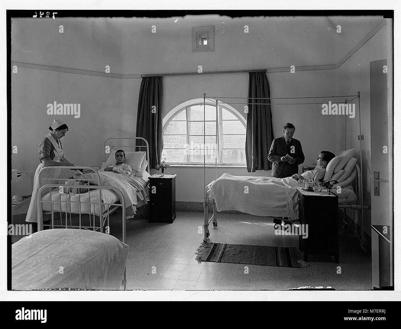 Questa immagine raffigura un reparto presso lo Scots Mission Hospital di Tiberias, che mostra due soldati britannici insieme all'infermiera Miss Lee e al reverendo Sloan. L'ospedale era un'importante istituzione medica durante il mandato britannico in Palestina. Foto Stock