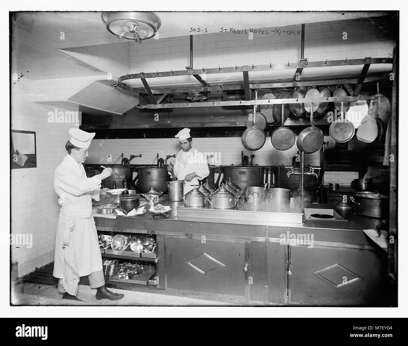 La cucina del St. Regis Hotel, New York, è ripresa in una fotografia storica, che mostra le pratiche culinarie e le operazioni di cucina dei primi anni del XX secolo in un ambiente di lusso. Foto Stock
