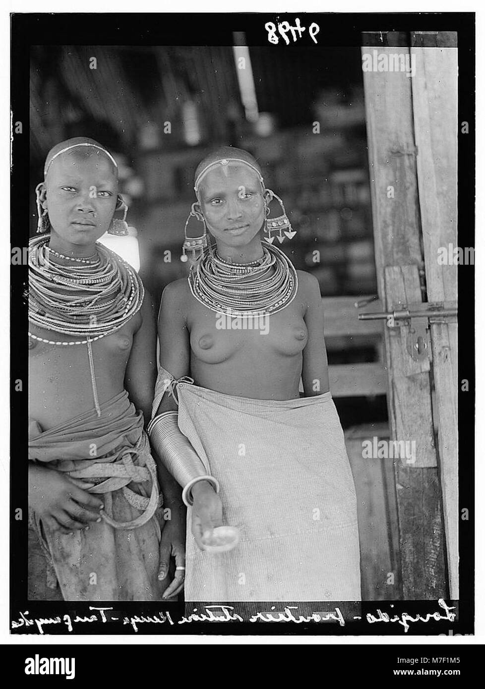 Fotografia che mostra due ragazze di Tanganica che portano anelli da collo, simboleggiando le tradizioni locali durante il loro viaggio a Longido. Foto Stock