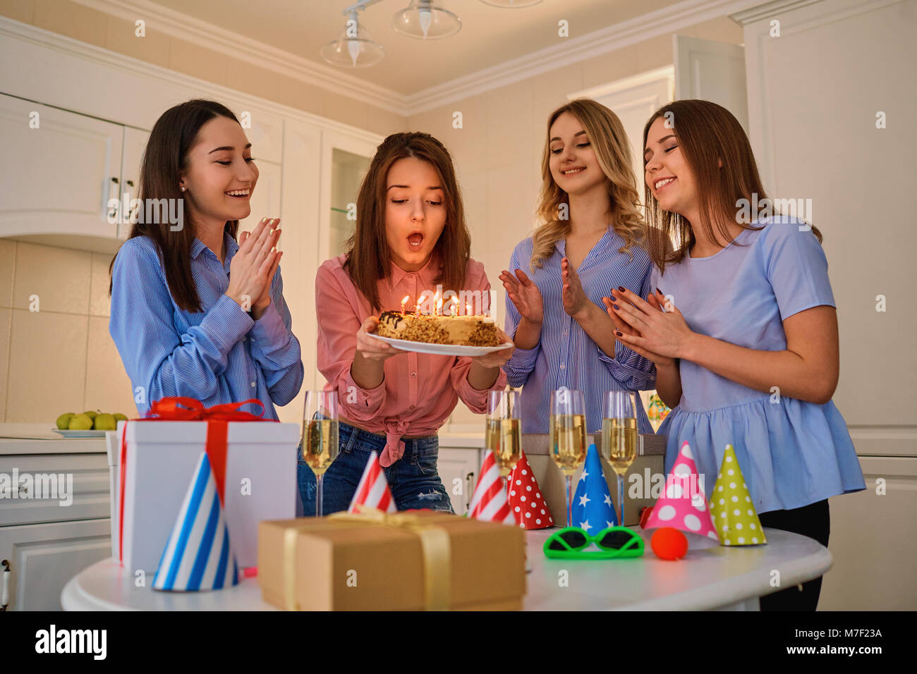 Un gruppo di amiche con una torta con candele di celebrare un birt Foto Stock