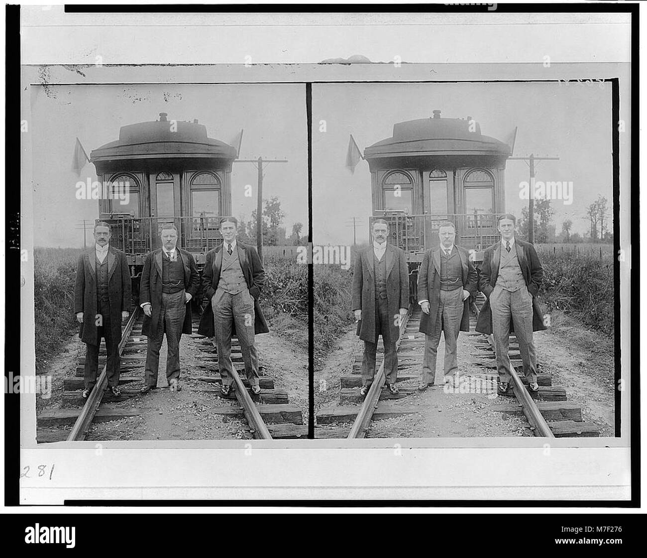 Un ritratto a figura intera di Theodore Roosevelt in piedi con altri due uomini di fronte a una macchina di osservazione ferroviaria, catturando il 26° presidente degli Stati Uniti in un momento di cameratismo e leadership. Foto Stock